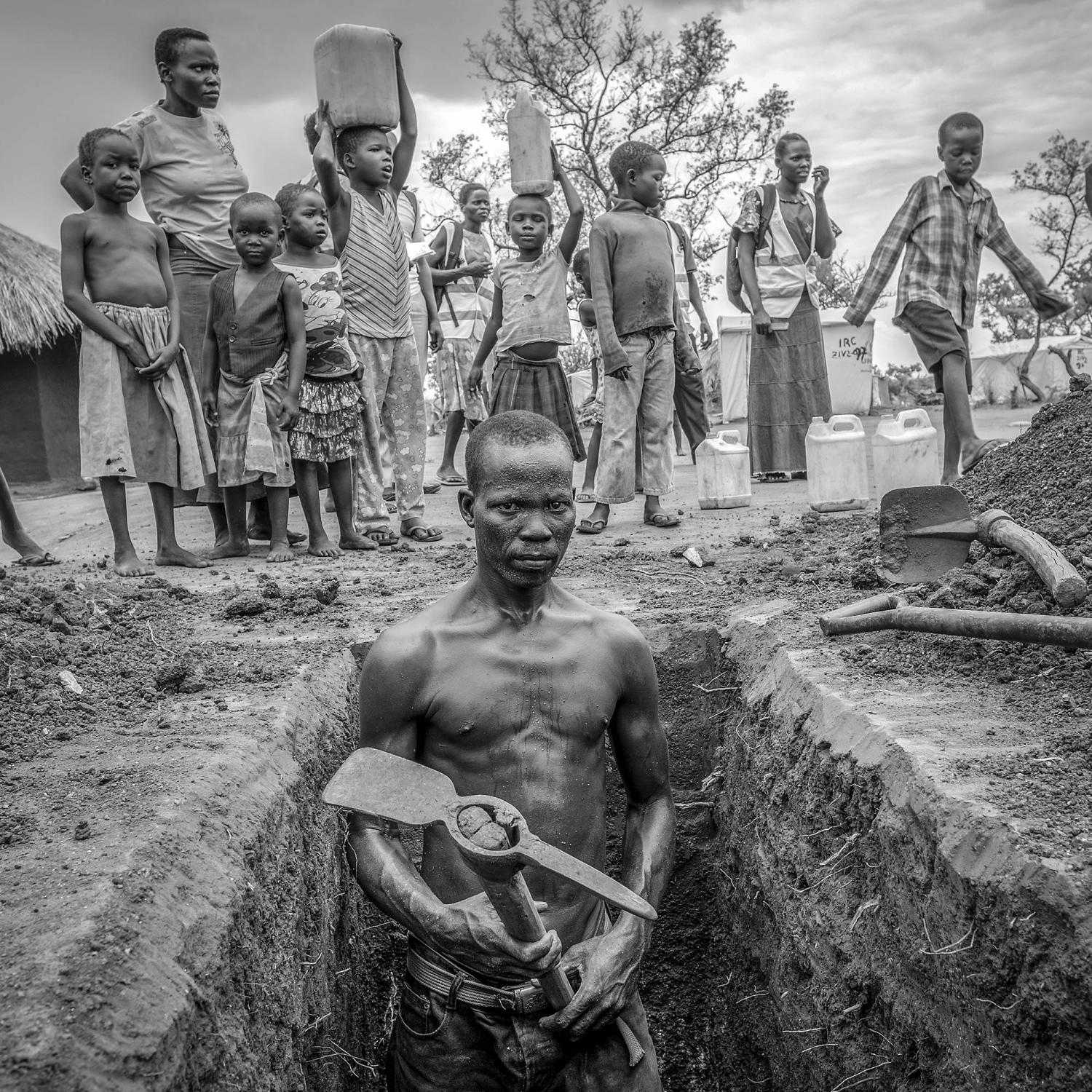Exodus: South Sudan -   Refugee from South Sudan digs a latrine at Bidoibidi...