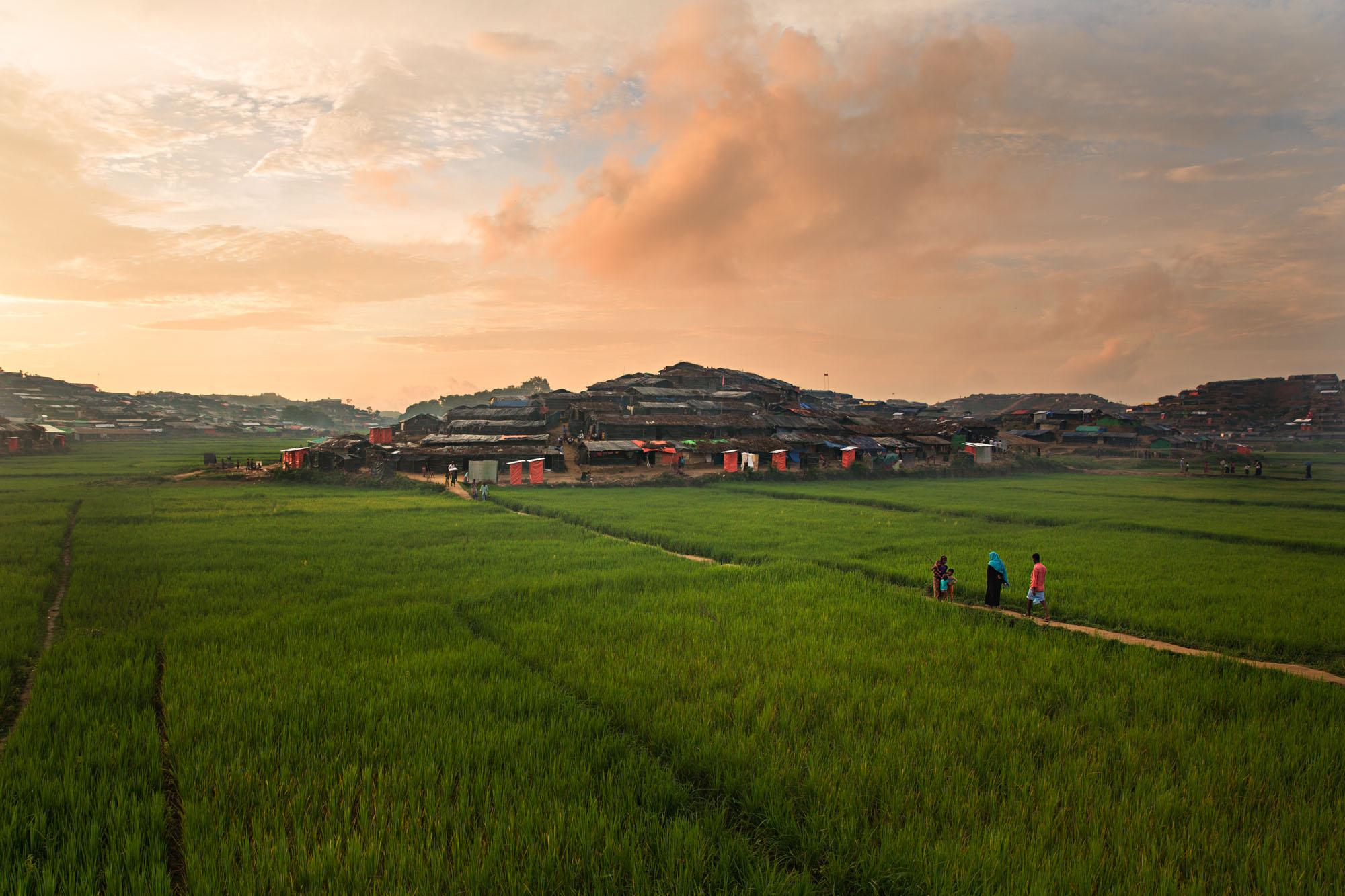 Exodus -  The sun sets on a Rohingya refugee camp outside of...
