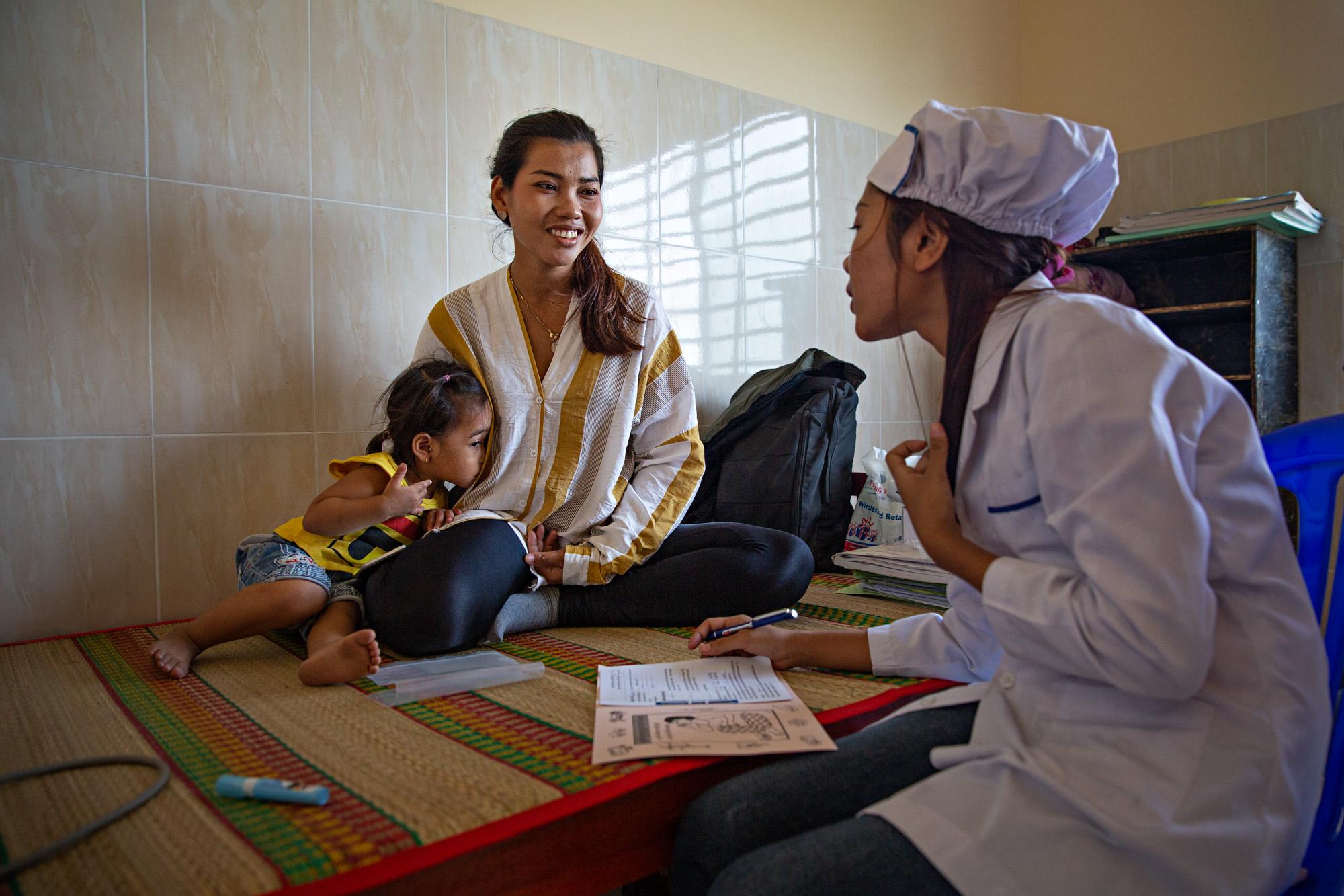 A mother brings her daughter to a healthcare clinic in rural Cambodia, April 2019.