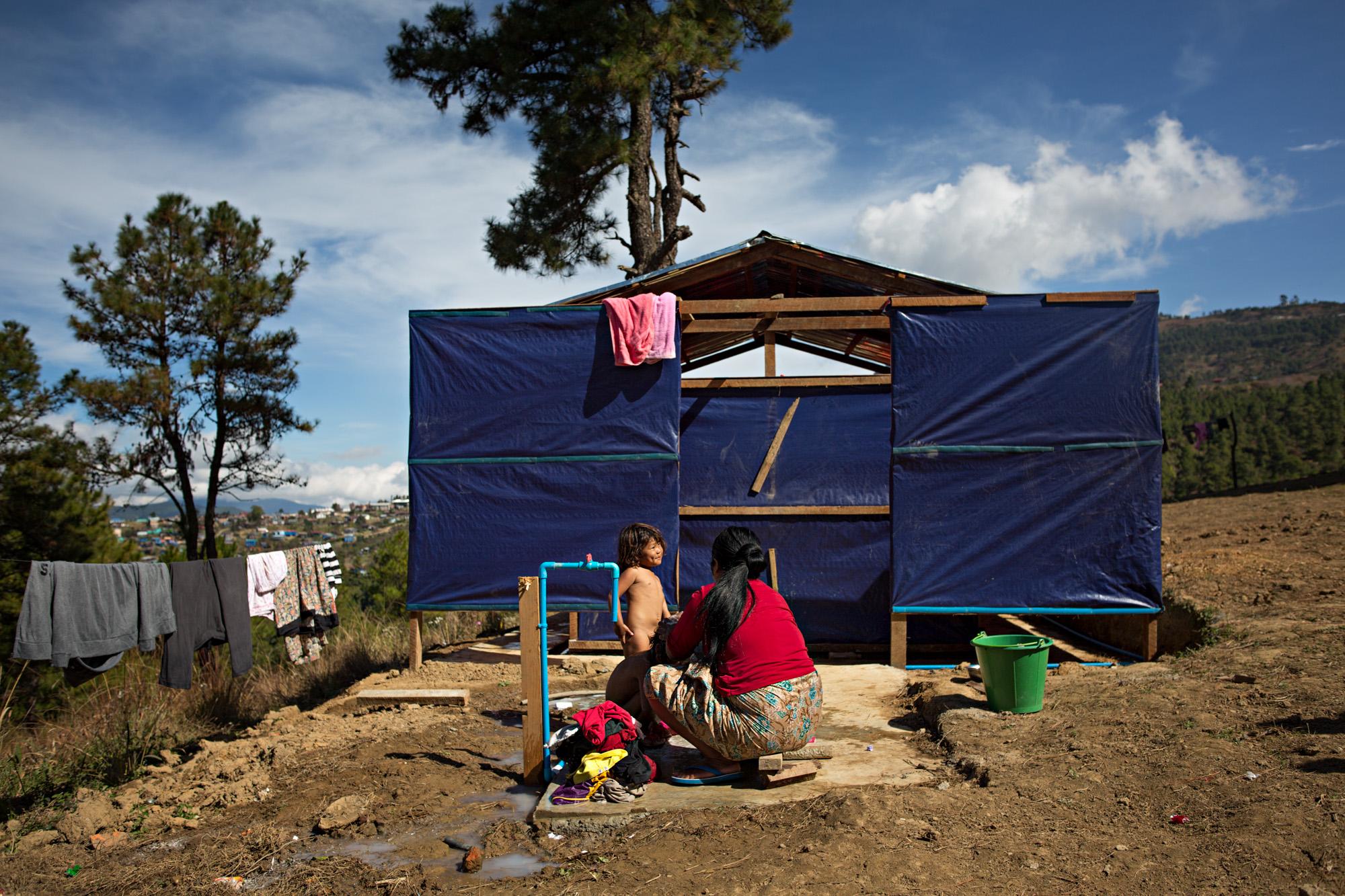 NGO - A mother washes her child at a makeshift lavatory and...