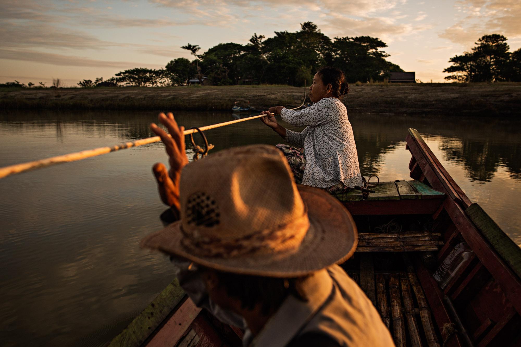Travel - A woman operates a boat carrying passengers across a...