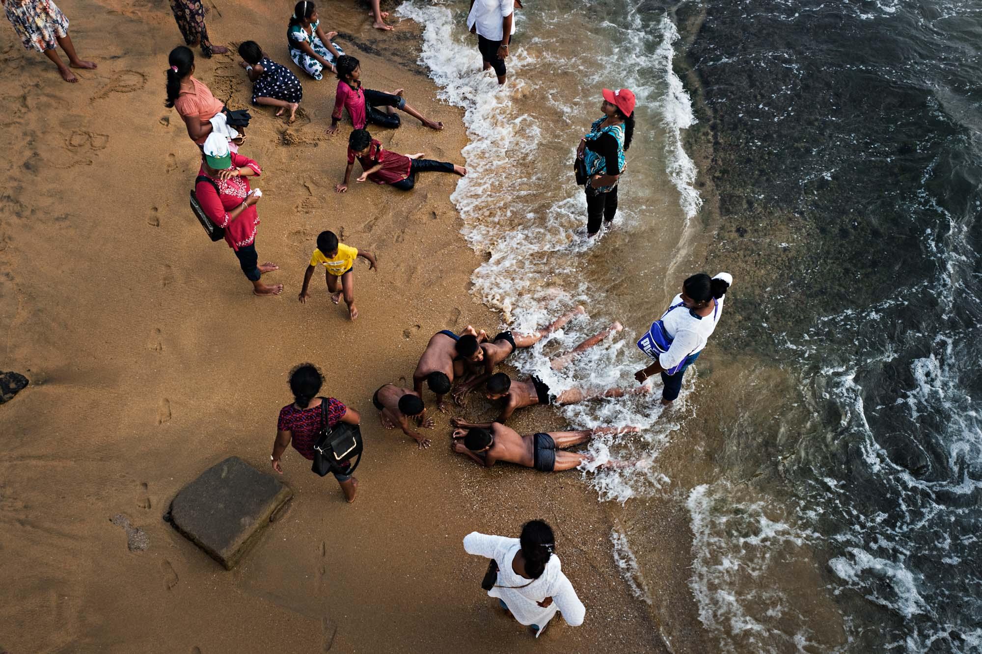 Travel - People cool off in the ocean at Galle Face Green beach in...