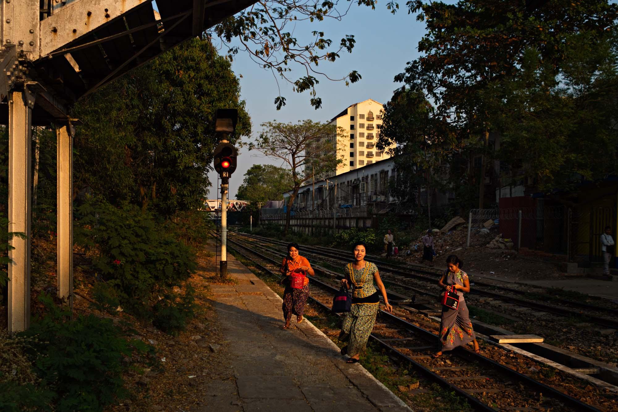 Travel - Women race across tracks to catch their train at a...
