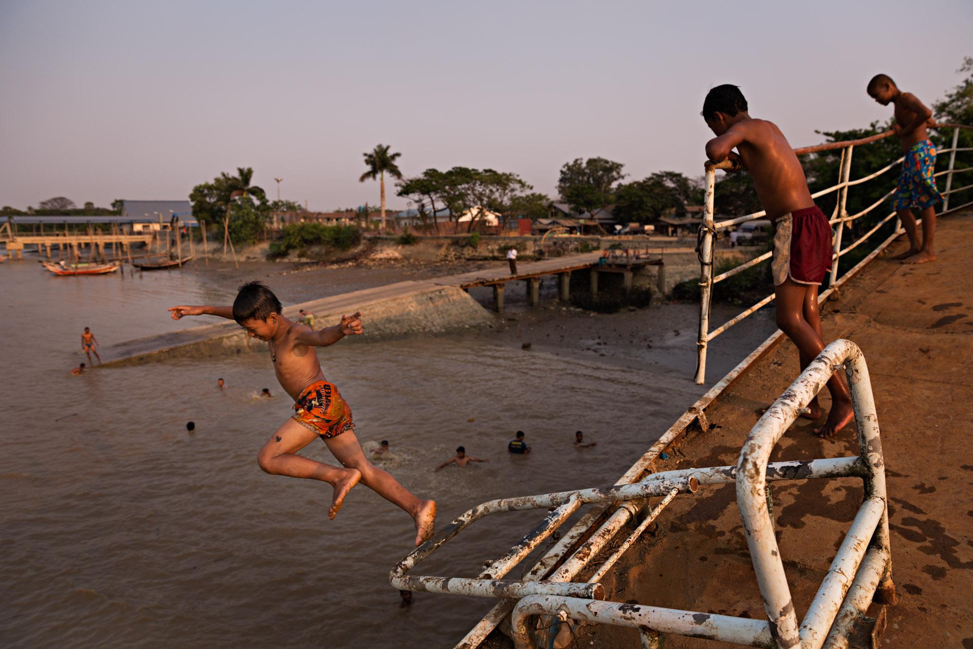 Travel - Boys jump into the Yangon river from an abandoned ferry...