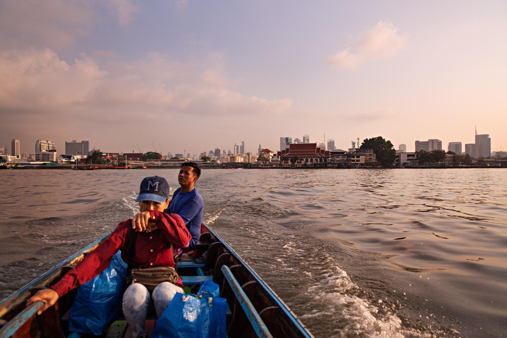 Travel - A woman takes a long tail boat across the Chao Praya...