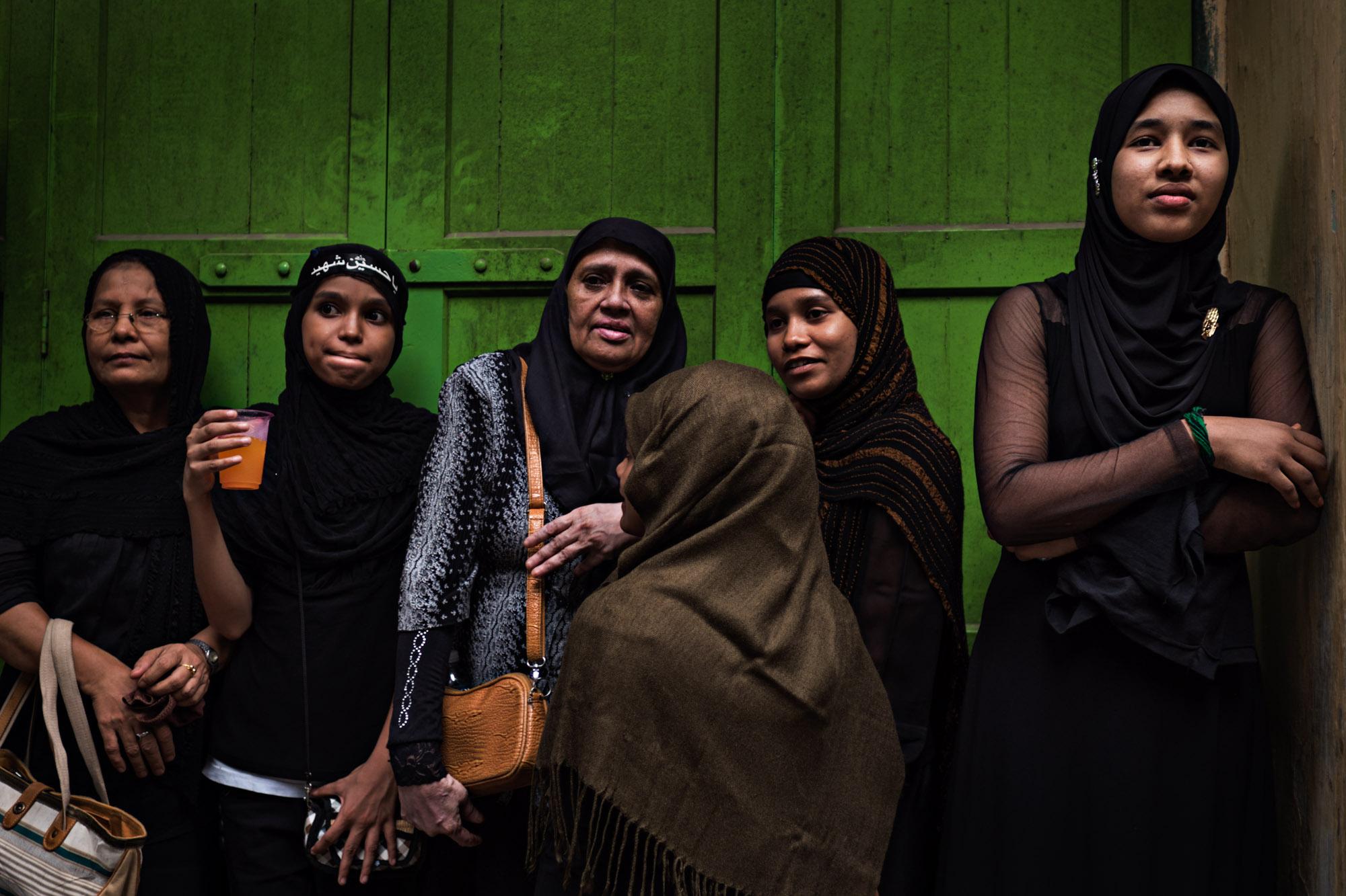 Singles -  Muslim women watch Ashura from a doorway in Yangon,...