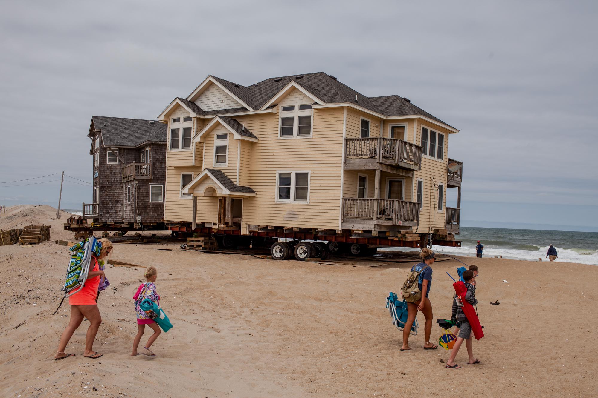 Shifting Sands - A family walks to the beach across what was once ocean-front property to several Rodanthe, North...