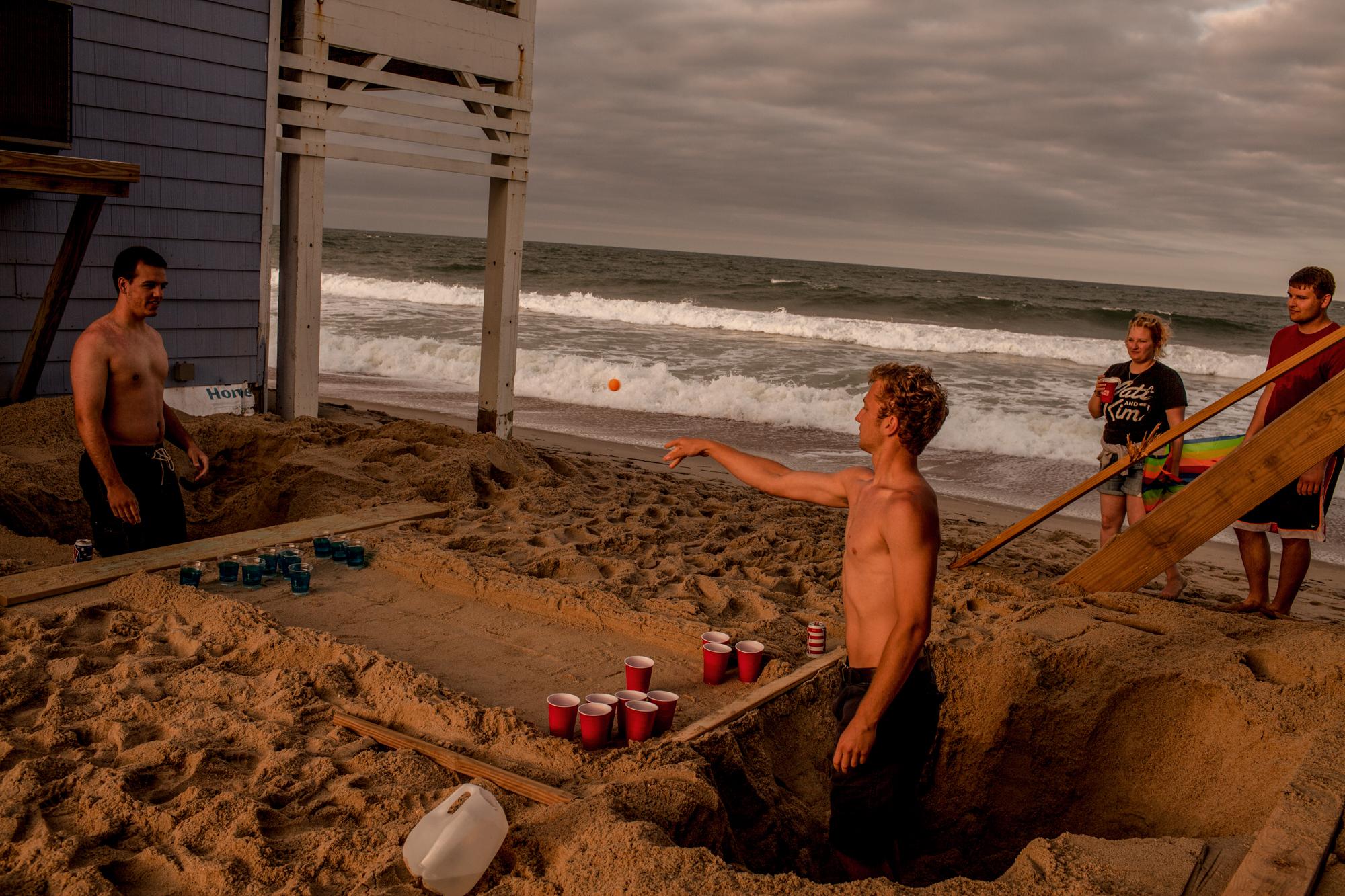 Shifting Sands - Friends from Ohio play a modified drinking game in holes they dug outside an oceanfront vacation...