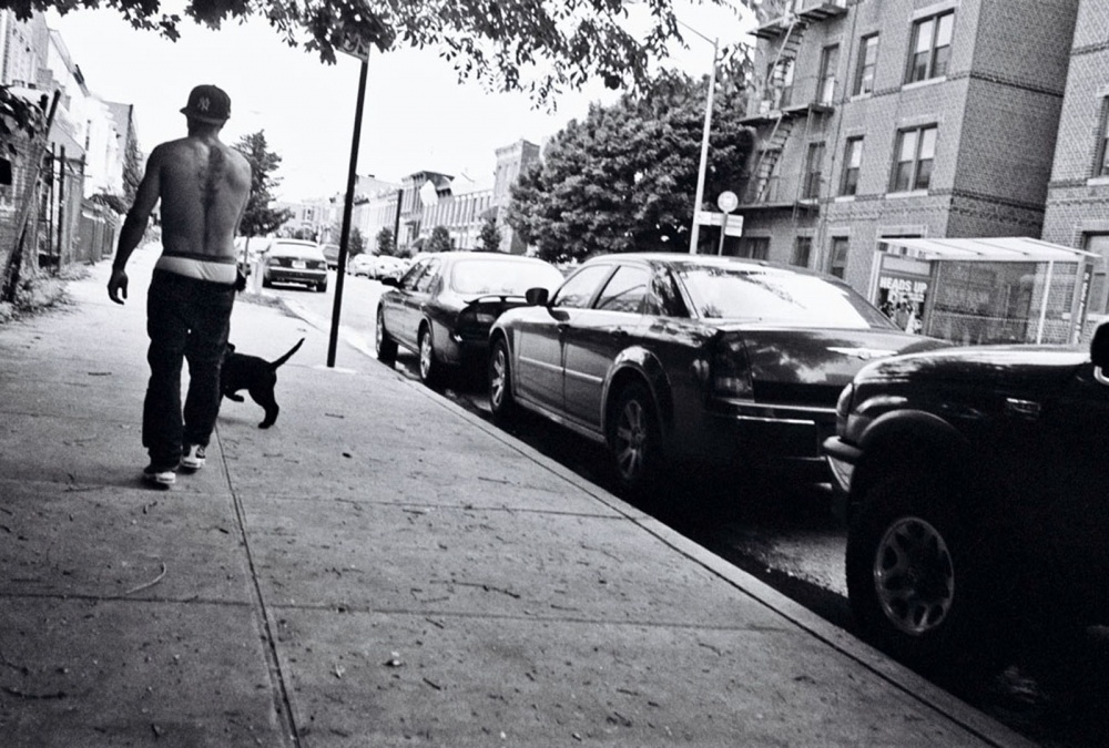 A young gang member walking his... neighborhood of Crown Heights.
