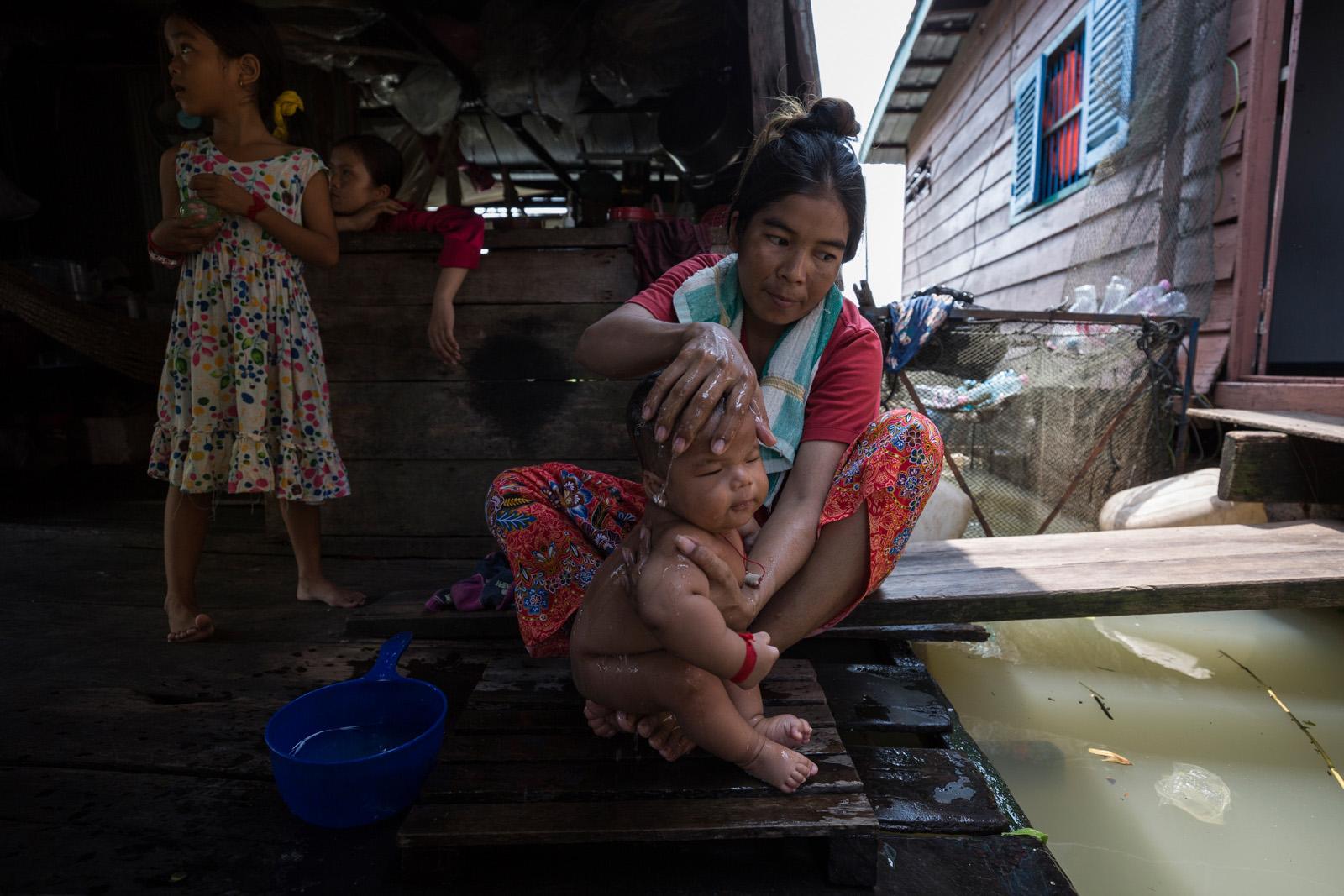 SOUTHEAST ASIA'S DENGUE EPIDEMIC - Ms Hourn washes her baby on their floating house in Prek...