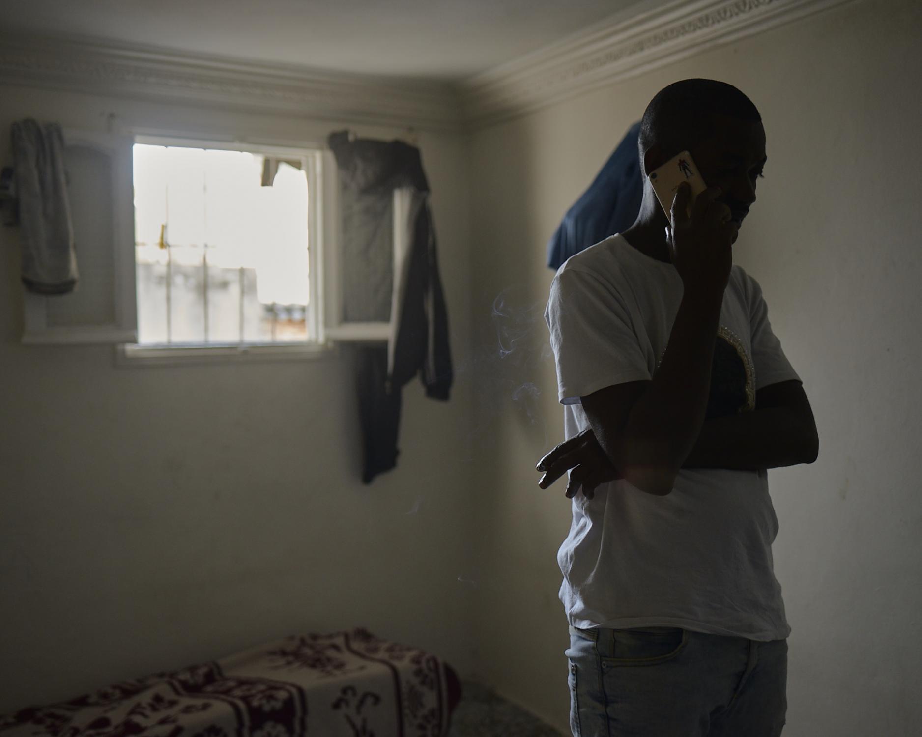 SALUT MAMAN: Crossing Morocco -   Ismael, 25yr., Speaks on the phone, coordinating the...