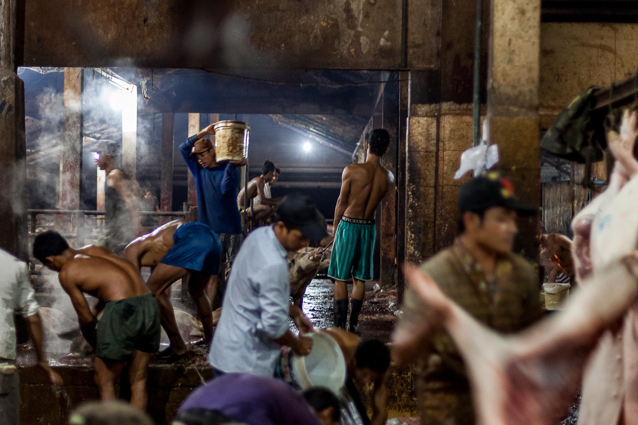 Inside a Cambodian Slaughterhouse - SIEM REAP, CAMBODIA - FEBRUARY 22: A young worker rests...