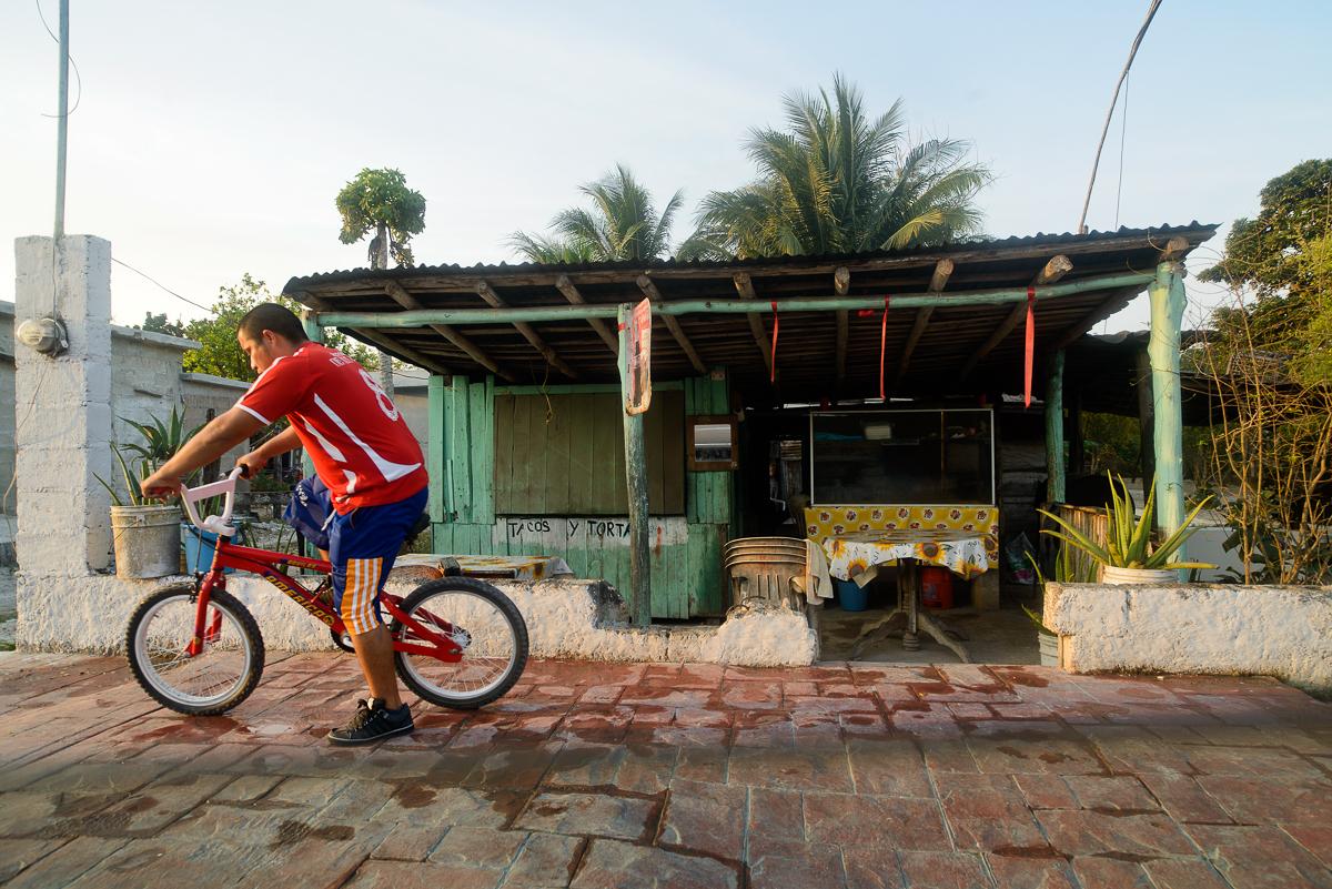 A Man Bikes to work Bacalar.