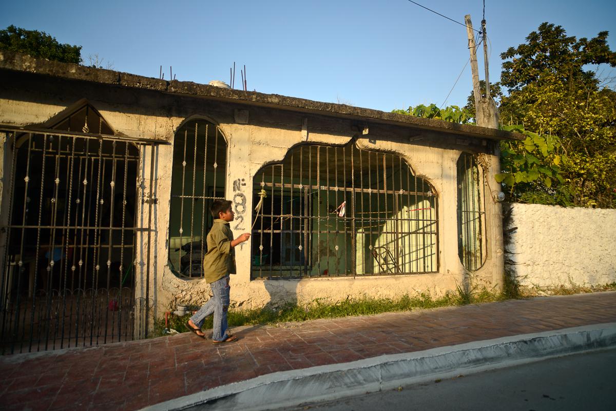 A Boy walks home alone, twilight, Bacalar, Mexico.