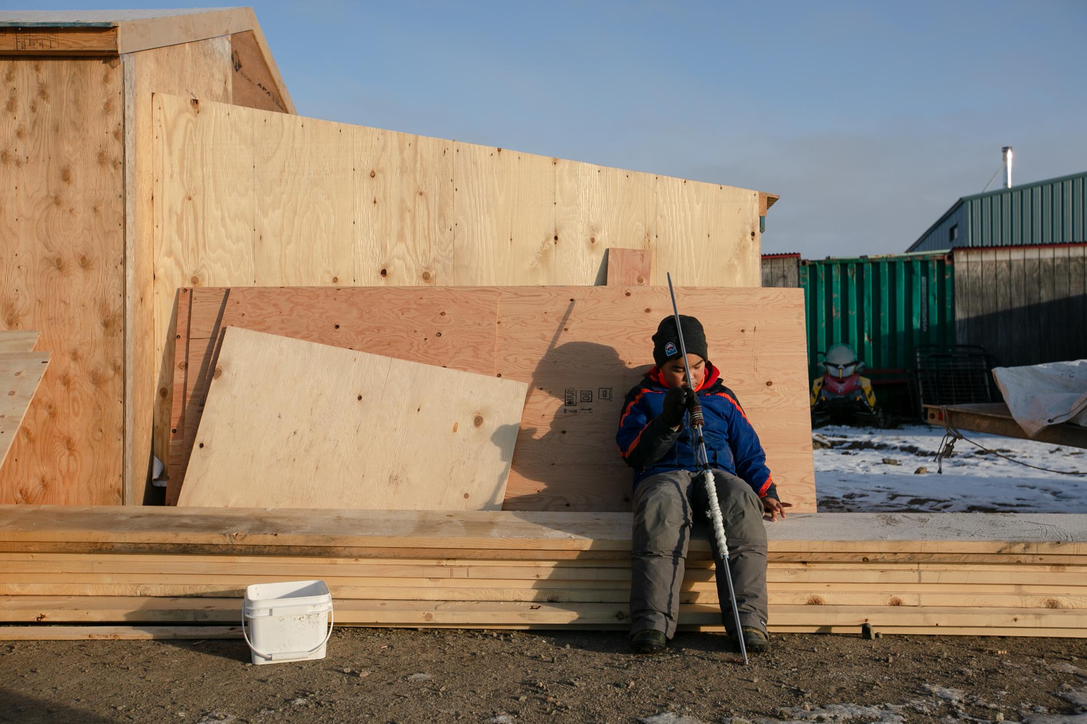 Nunavut's Young Hunters - Kaniq Allerton sits with his harpoon on a Sunday morning...