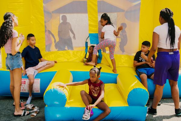 Block Party for NYT - Children play with inflatable bounce house at the block...