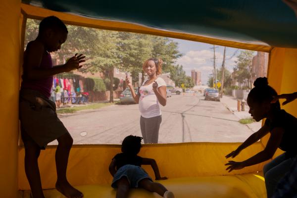 Block Party for NYT - Tiffany Moreau looks out for her kid playing inside the...