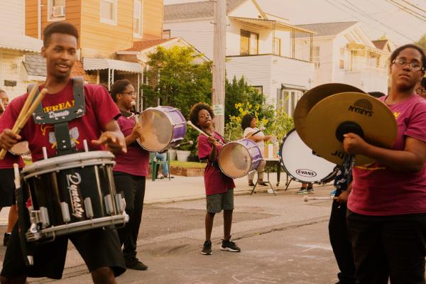 Image from Block Party for NYT - The Berean Community Drumline marches during the block...