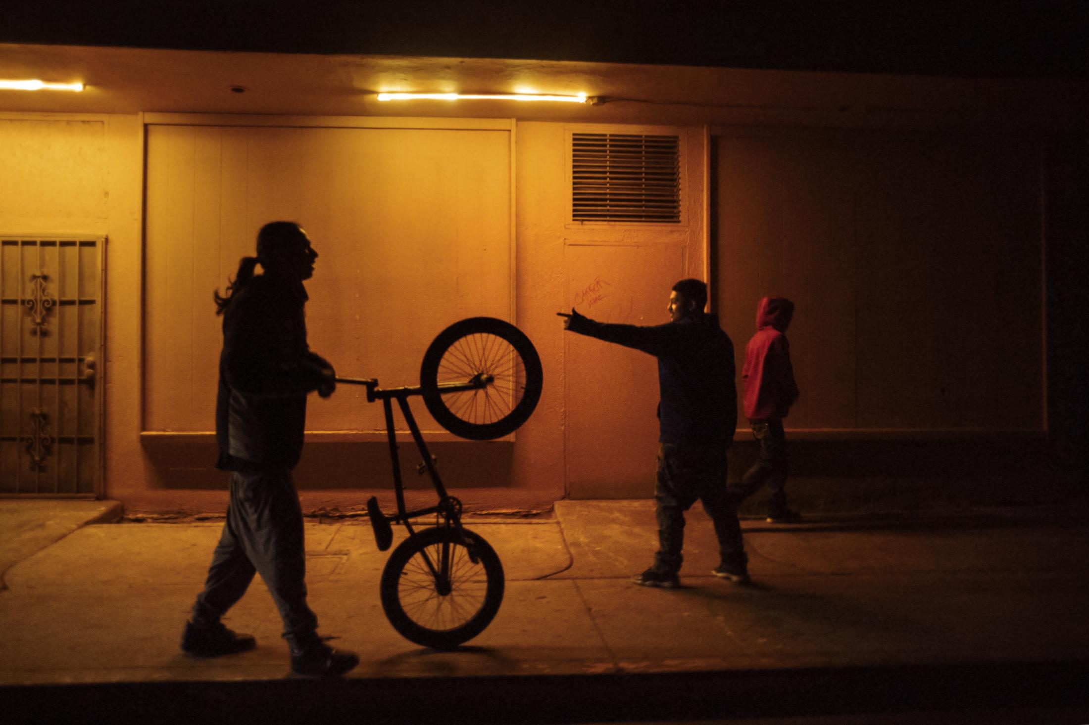 TRG (Tiny Rascal Gang) gang members quickly leave an area as one of their members is questioned by a MAGEC (gang unit) police officer in Fresno.