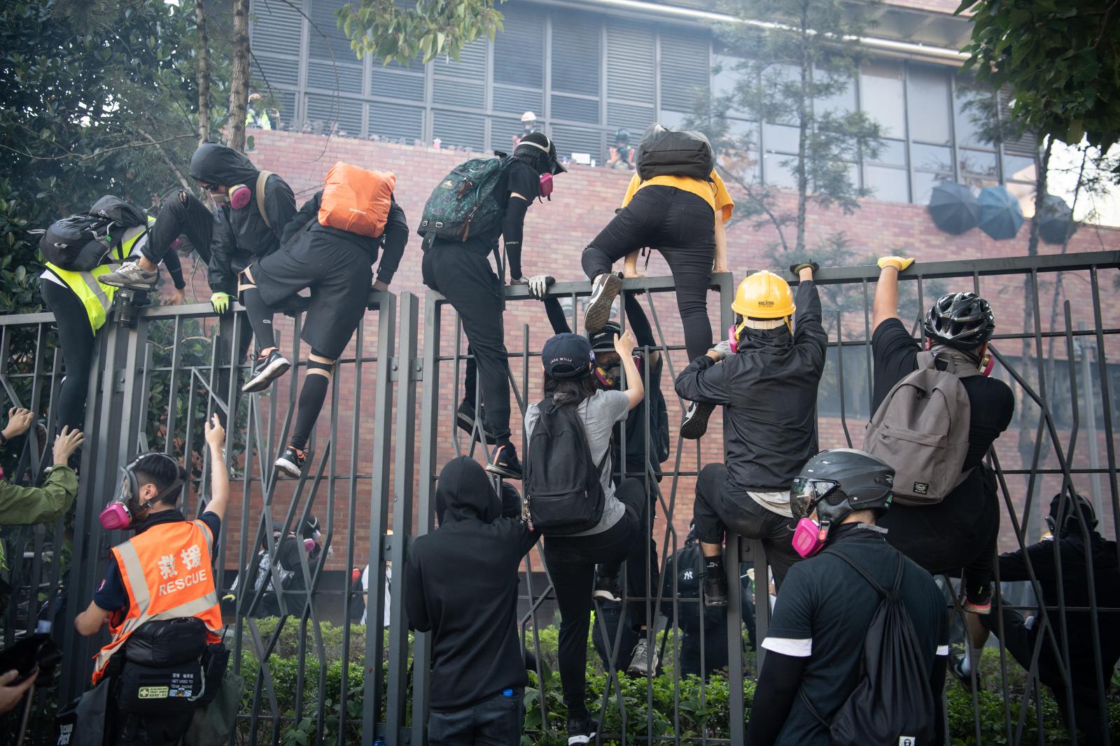 HONG KONG, CHINA - NOVEMBER 18: Anti-government protesters flee after clashing with police at Hong Kong Polytechnic University on November 18, 2019 in Hong Kong, China. Anti-government protesters organized a general strike since Monday as demonstrations in Hong Kong stretched into its sixth month with demands for an independent inquiry into police brutality, the retraction of the word "riot" to describe the rallies, and genuine universal suffrage. (Photo by Laurel Chor/Getty Images)