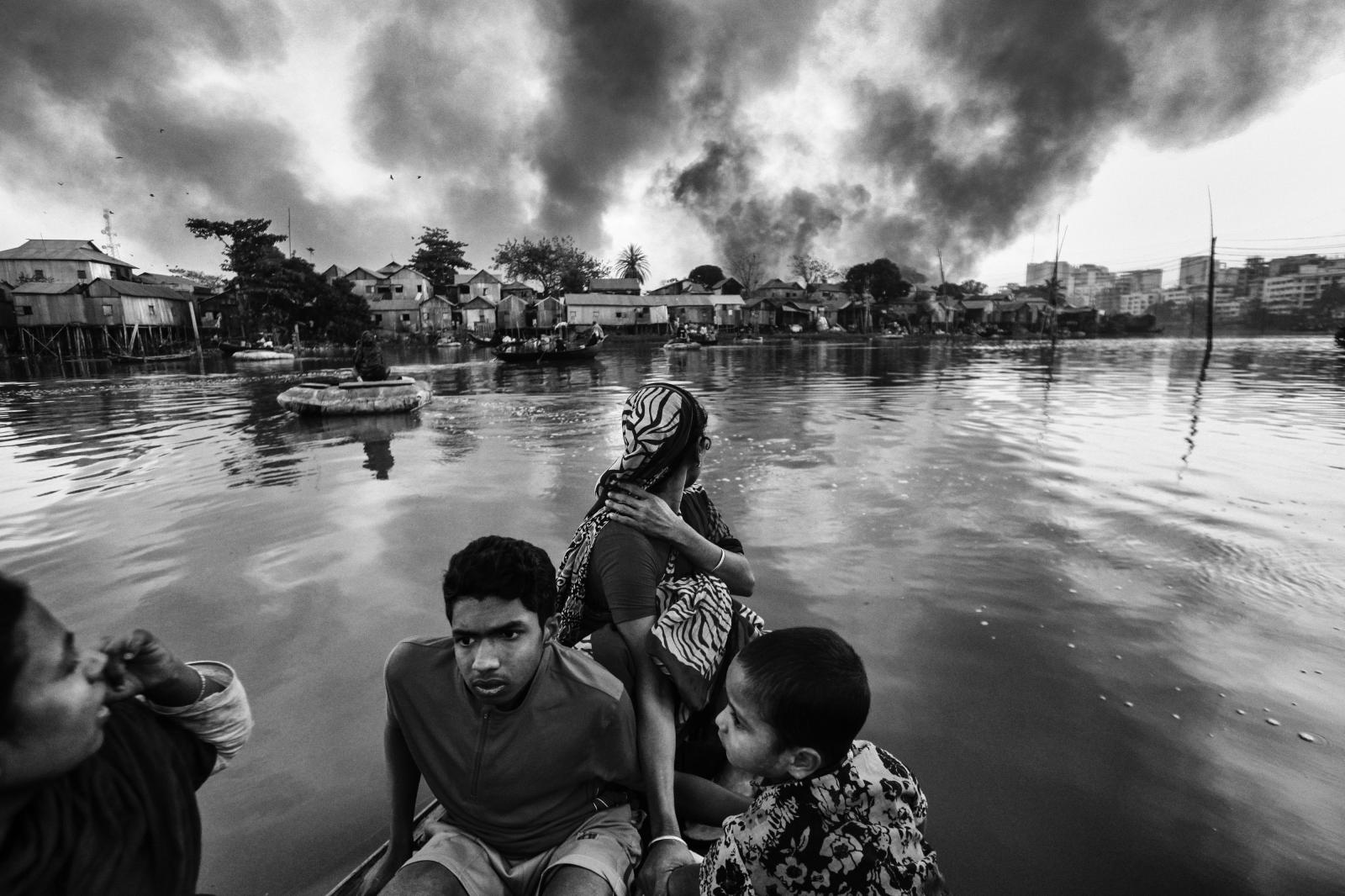 Slum dwellers crossing a lake b...ve hours to put out the flames.