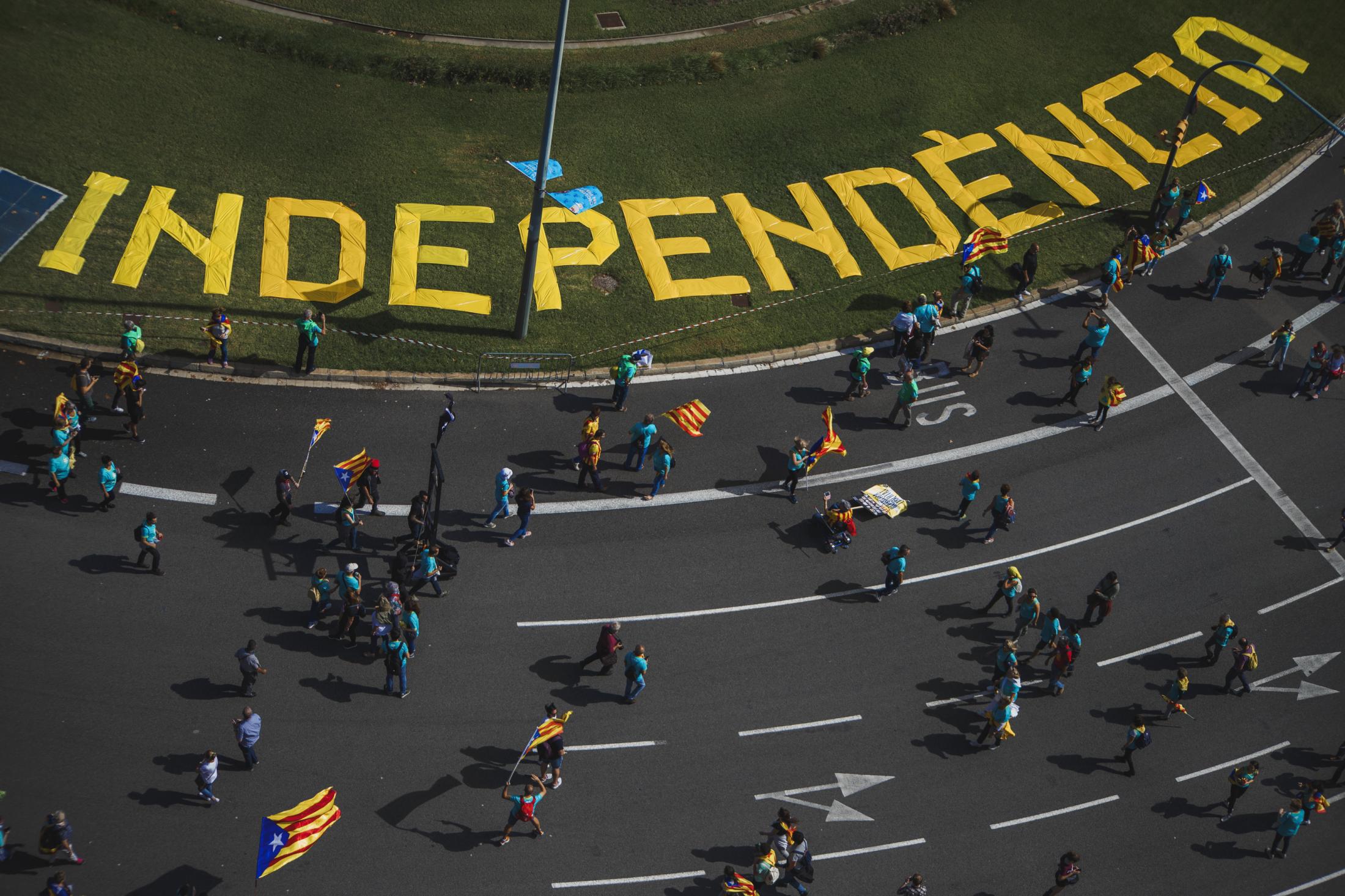 People walking with symbols and flags for independence during the Catalan National day known as...
