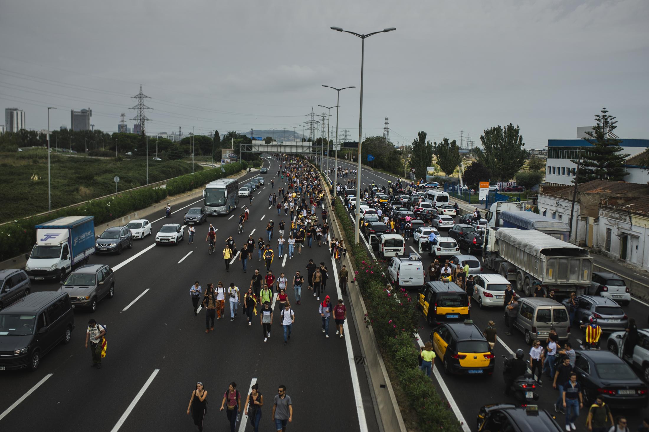 People walking on the highway to head to the airport. (October 14,2019. Barcelona, Spain)&nbsp;