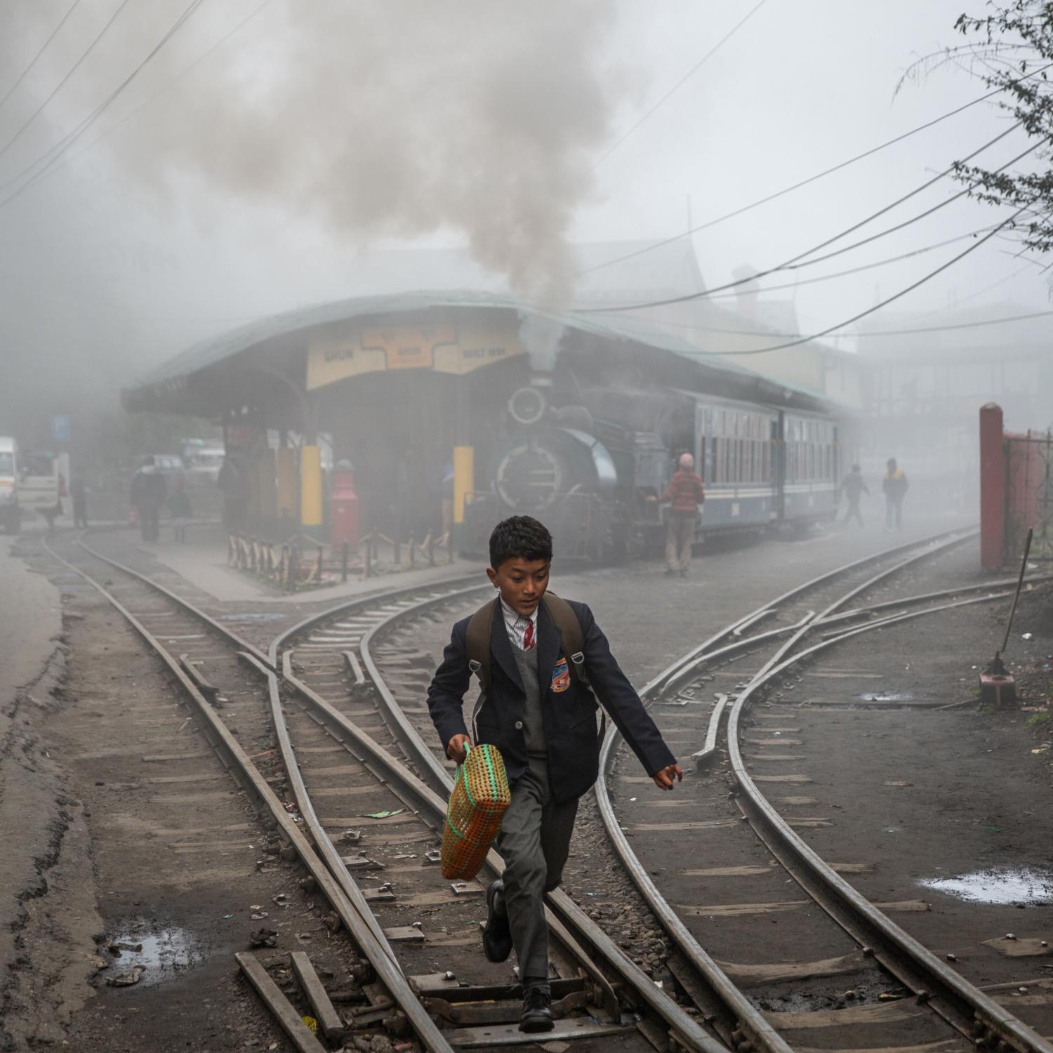 Single images - A little boy runs along the train tracks outside of Ghum...