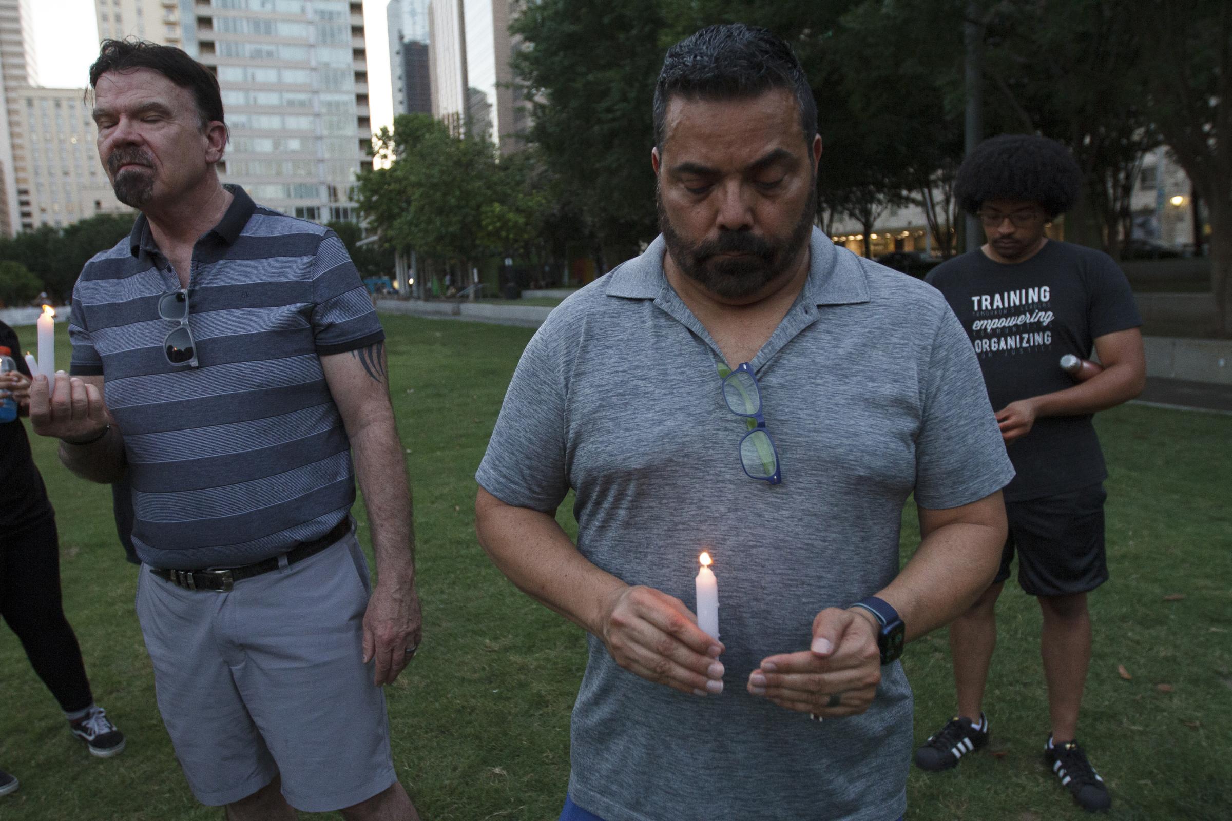 Candlelight Vigil for the Buffalo and Uvalde gun violence victims - David Weinerth (left) and John Gutierrez hold lit candles during the candlelight vigil in honor...