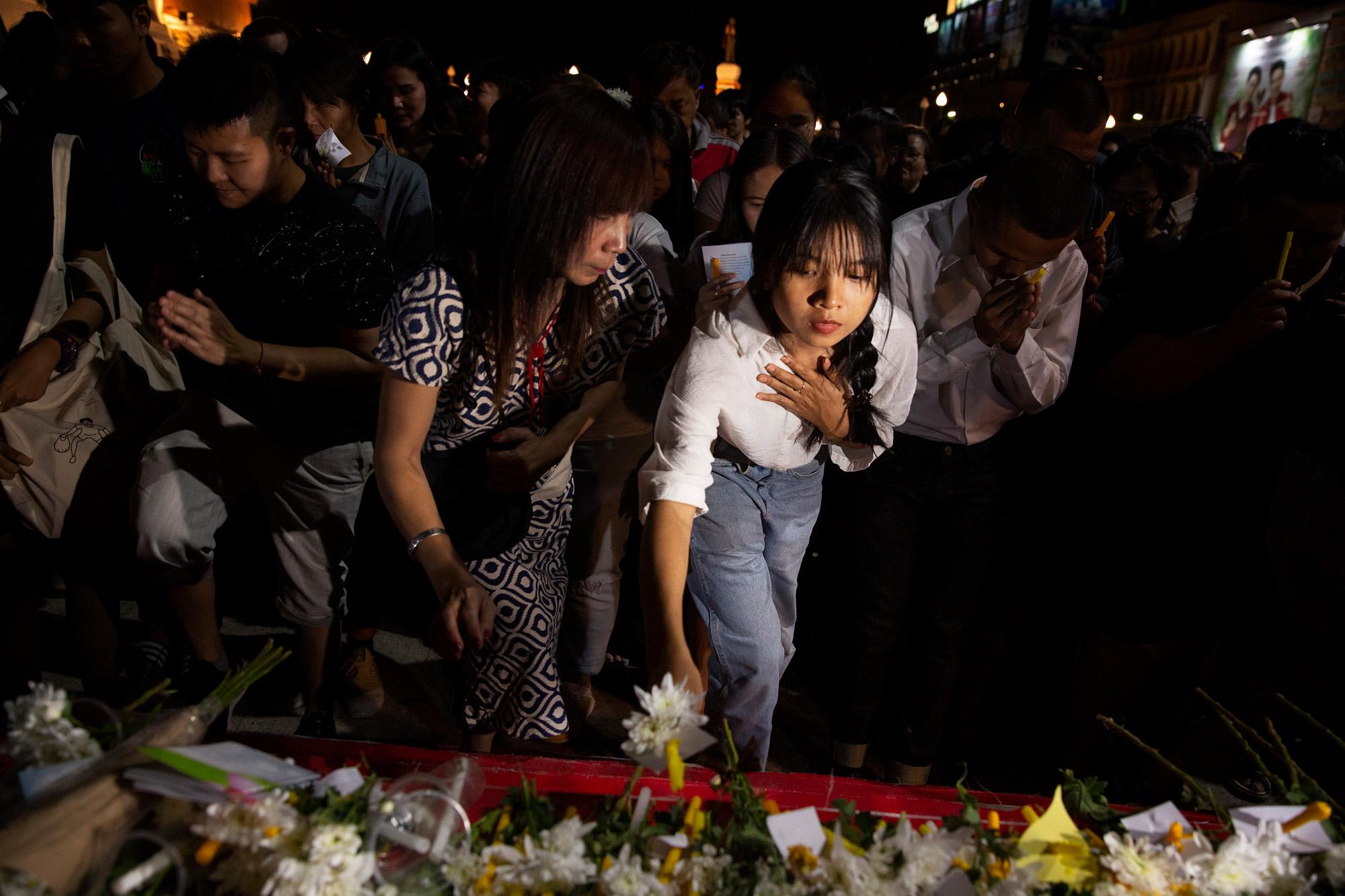 Shooting in Korat, Thailand: The New York Times - A woman lays down a flower during a memorial for those...