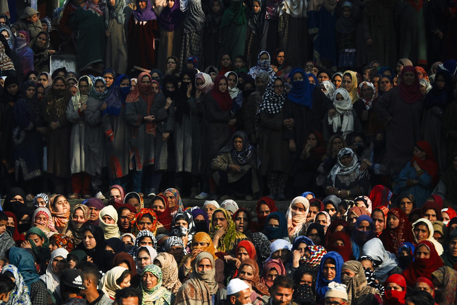 Kashmir-The Never Ending War - Women watch the funeral procession of a local militant...