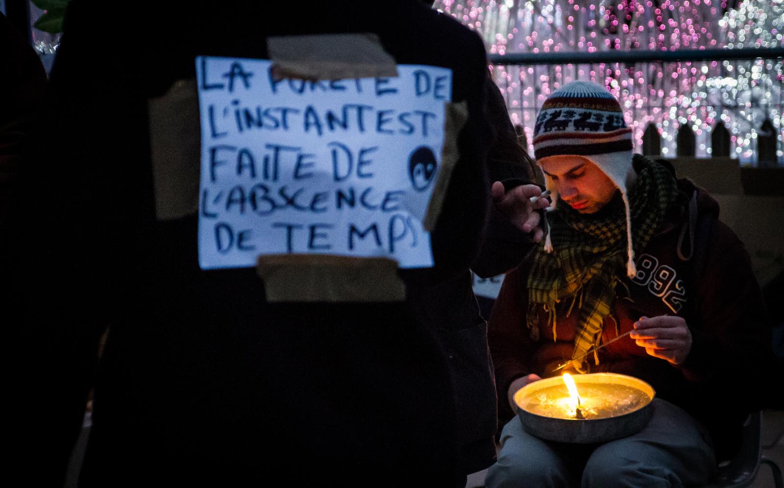 Occupy la Défense - Man lighting a big candle on the 14th day of Occupy La...