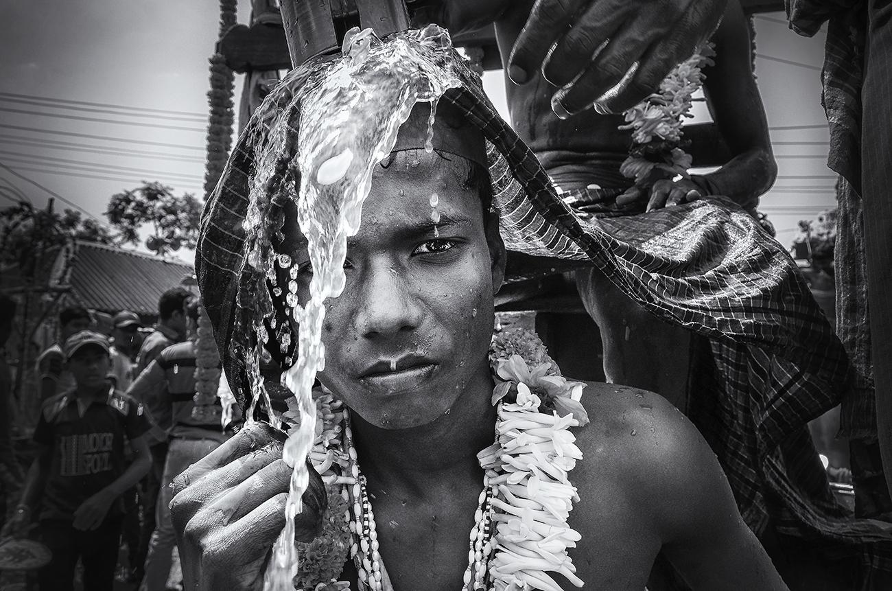 Portraits - People are putting water on the head of a boy during the...