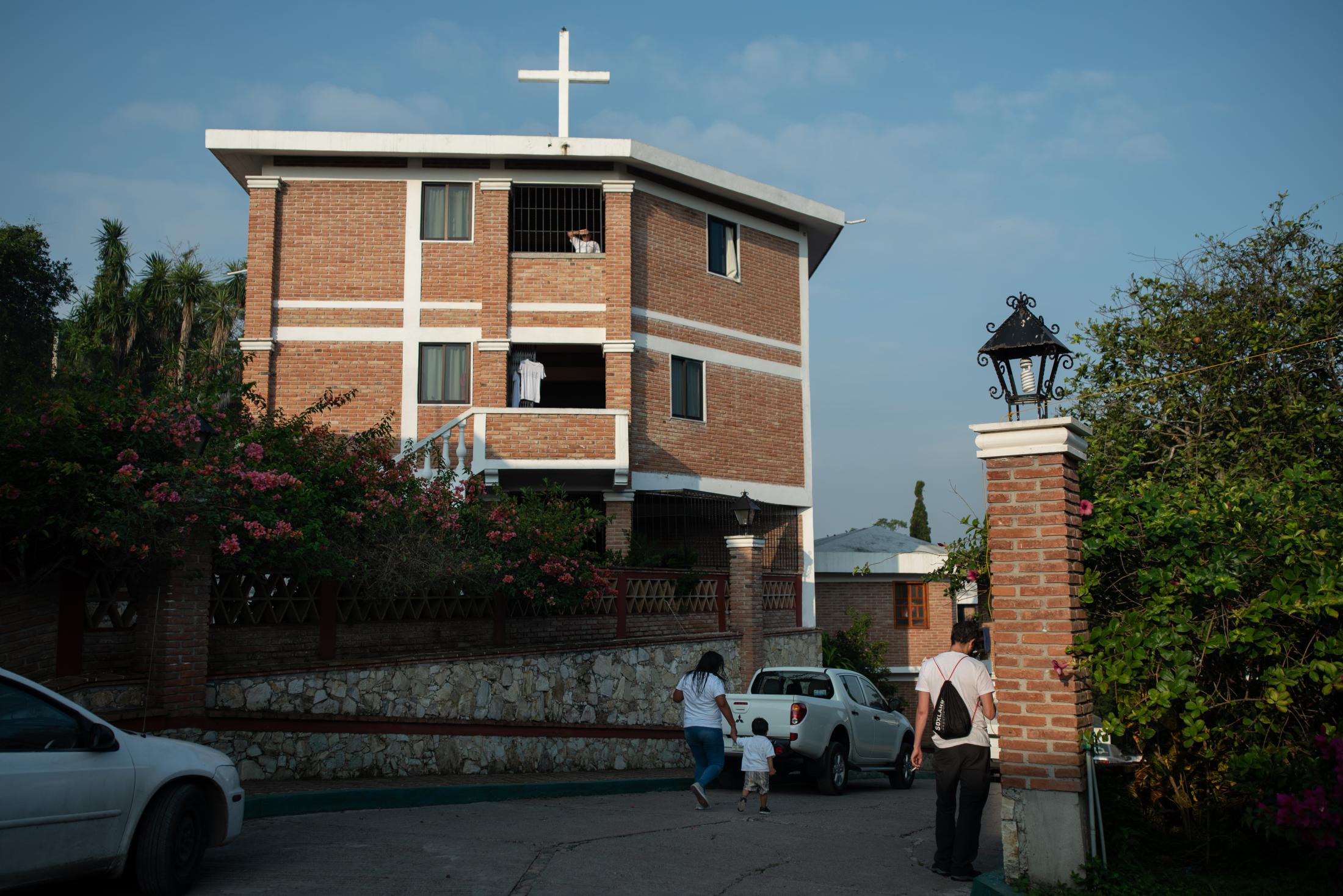 A woman and her child walks inside the Casa de la Iglesia center, where they housed about 300...