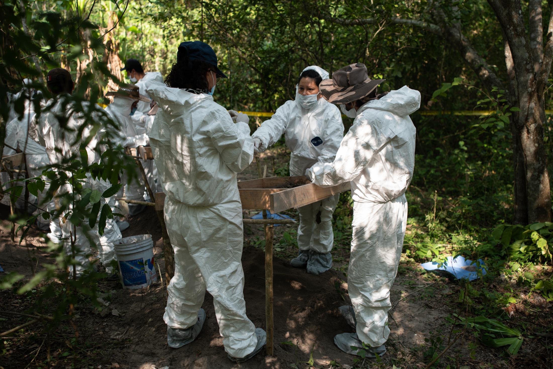 A group of relatives of missing persons and forensic experts work inside the ranch &quot;La...