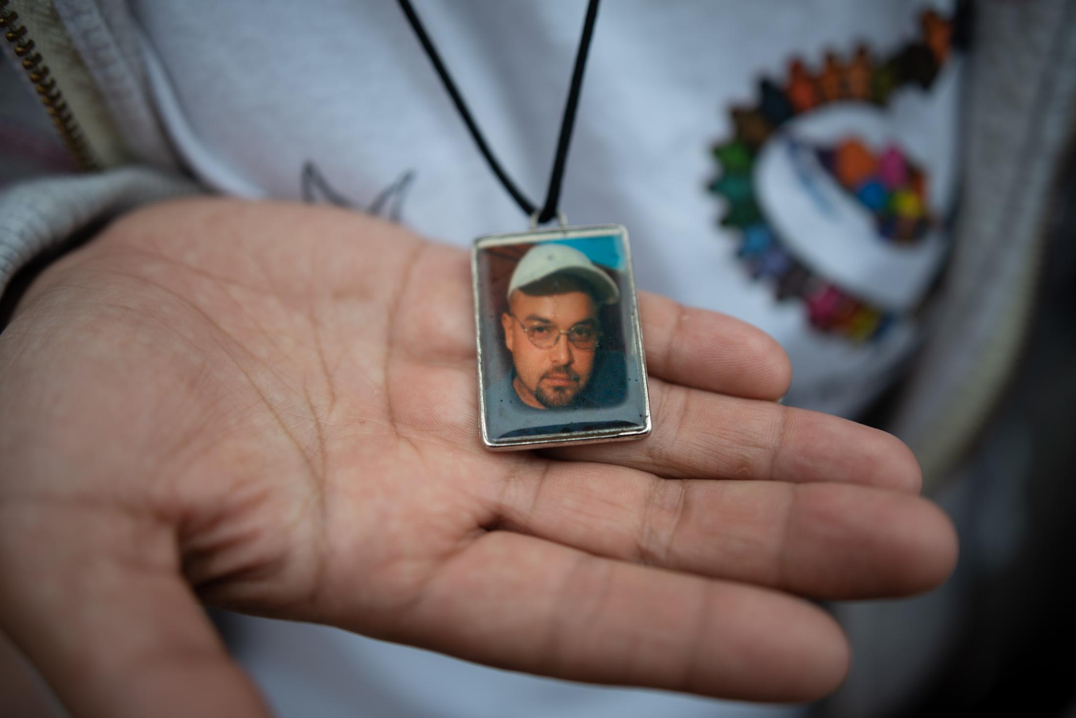 A woman shows the portrait of Gustavo Trujillo, who disappeared in 2010 in Poza Rica, Veracruz,...