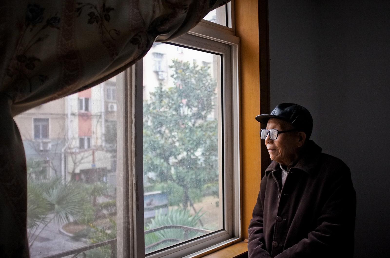 Standing by his bedroom window is his Nanjing apartment, Cao&#39;s memories of the massacre...
