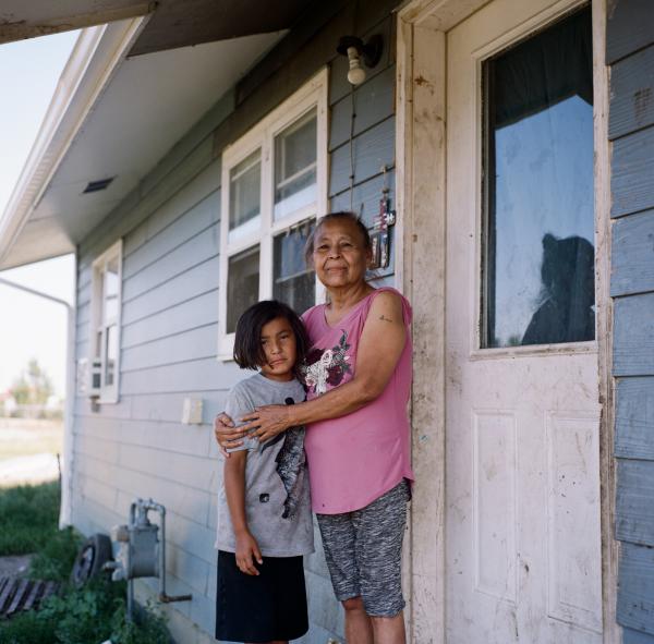 Valerie Whitehawk, 61, and her grand-daughter, Macylilly, 8, stand for a portrait outside of their home on Fort Peck Indian Reservation. Macylilly was kidnapped when she was approximately 4 years old and was sexually assaulted. She was found to have meth in her body due to the assailant&rsquo;s semen and contracted hepatitis C. The prevalence of drugs, particularly meth, exploded when the oil boom arrived.
