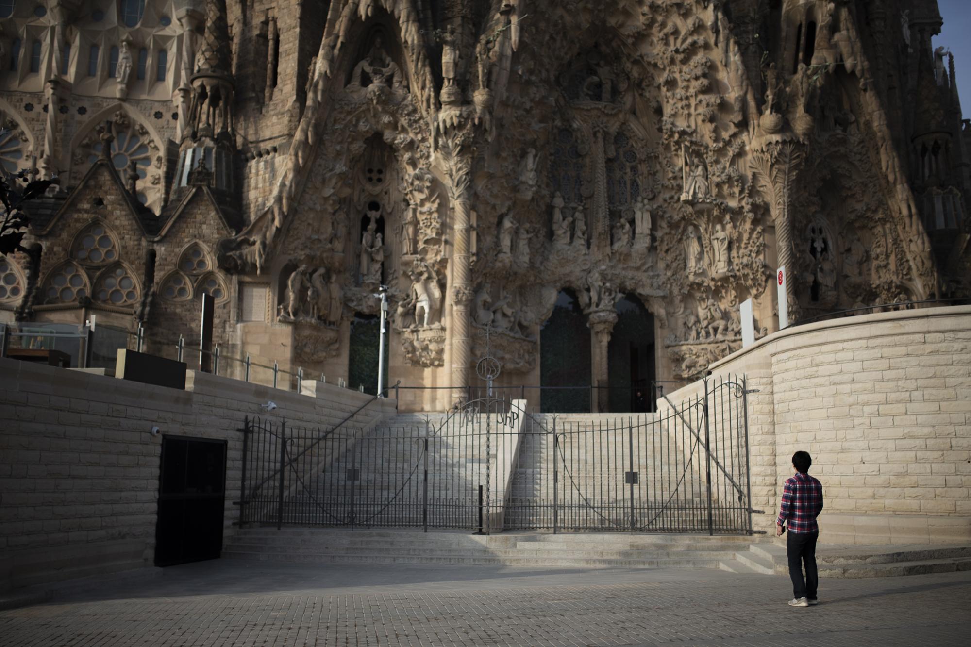 Covid 19 Daily News - A tourist stands outside the Sagrada Familia basilica in...