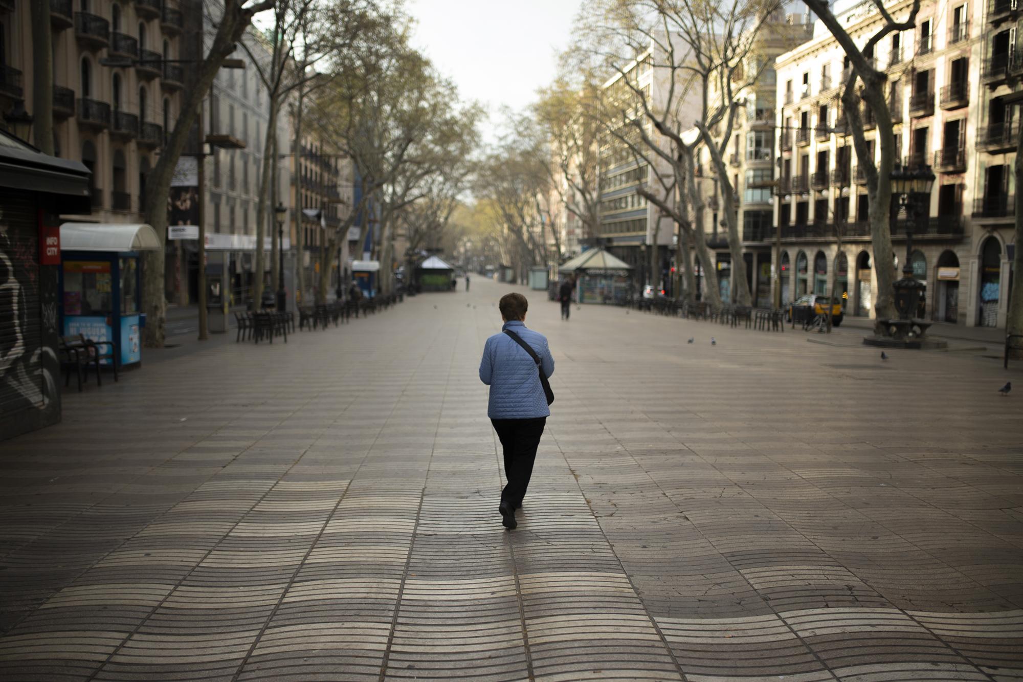 Covid 19 Daily News - A woman waks along La Ramblas in Barcelona, Spain,...