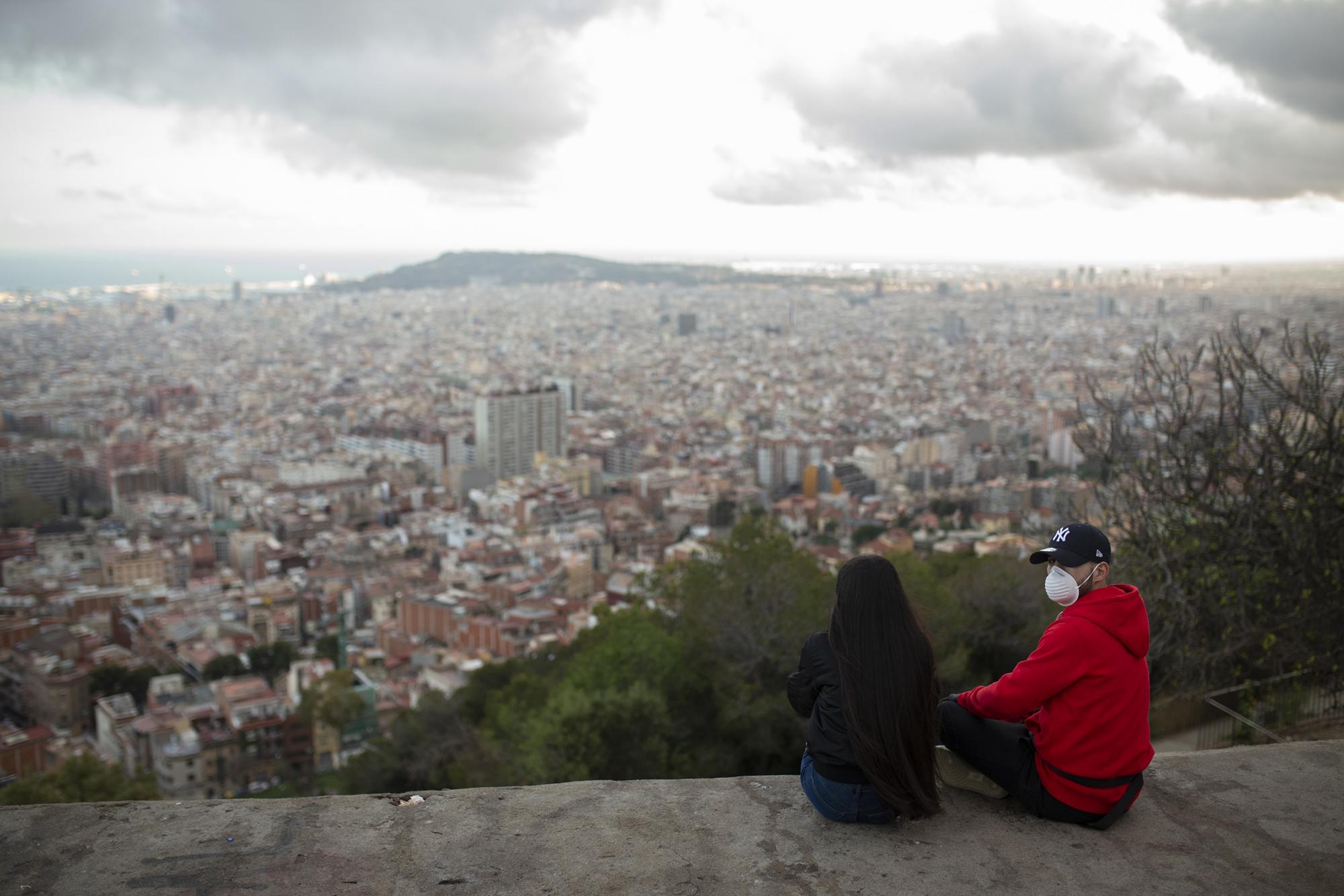 Covid 19 Daily News - A couple sit on a panoramic vantage point to watch the...