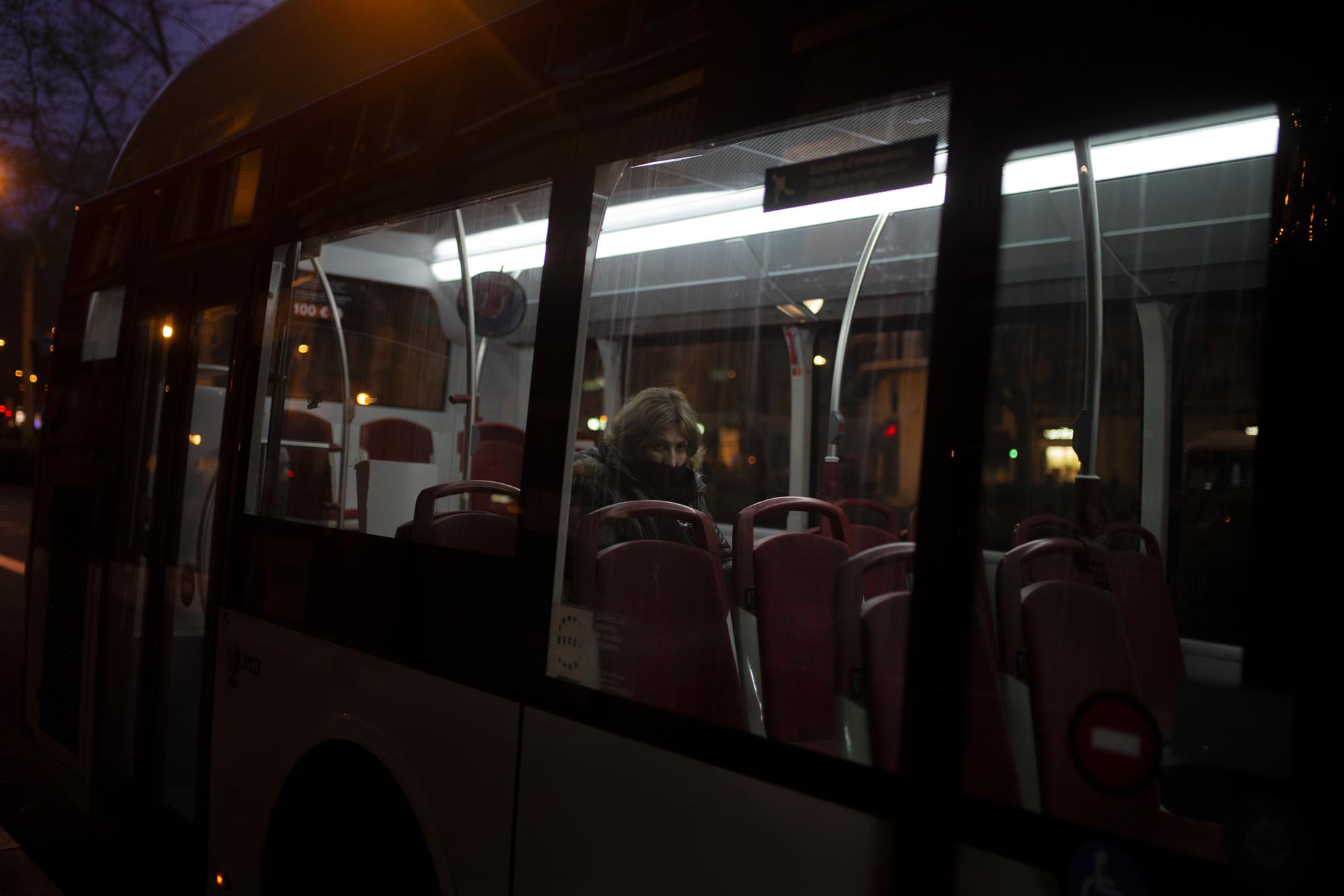 Covid 19 Daily News - A woman wearing a face mask travels by bus in Barcelona.