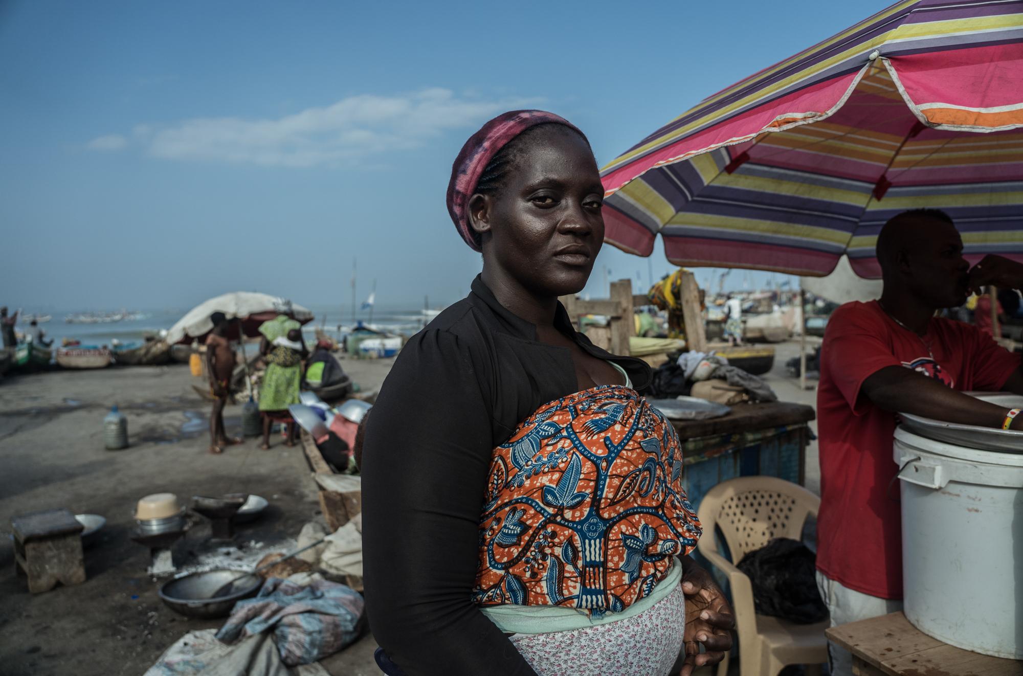 The Battle For Fish - Fish vendor Mercy Allotey waits at the beachfront in...