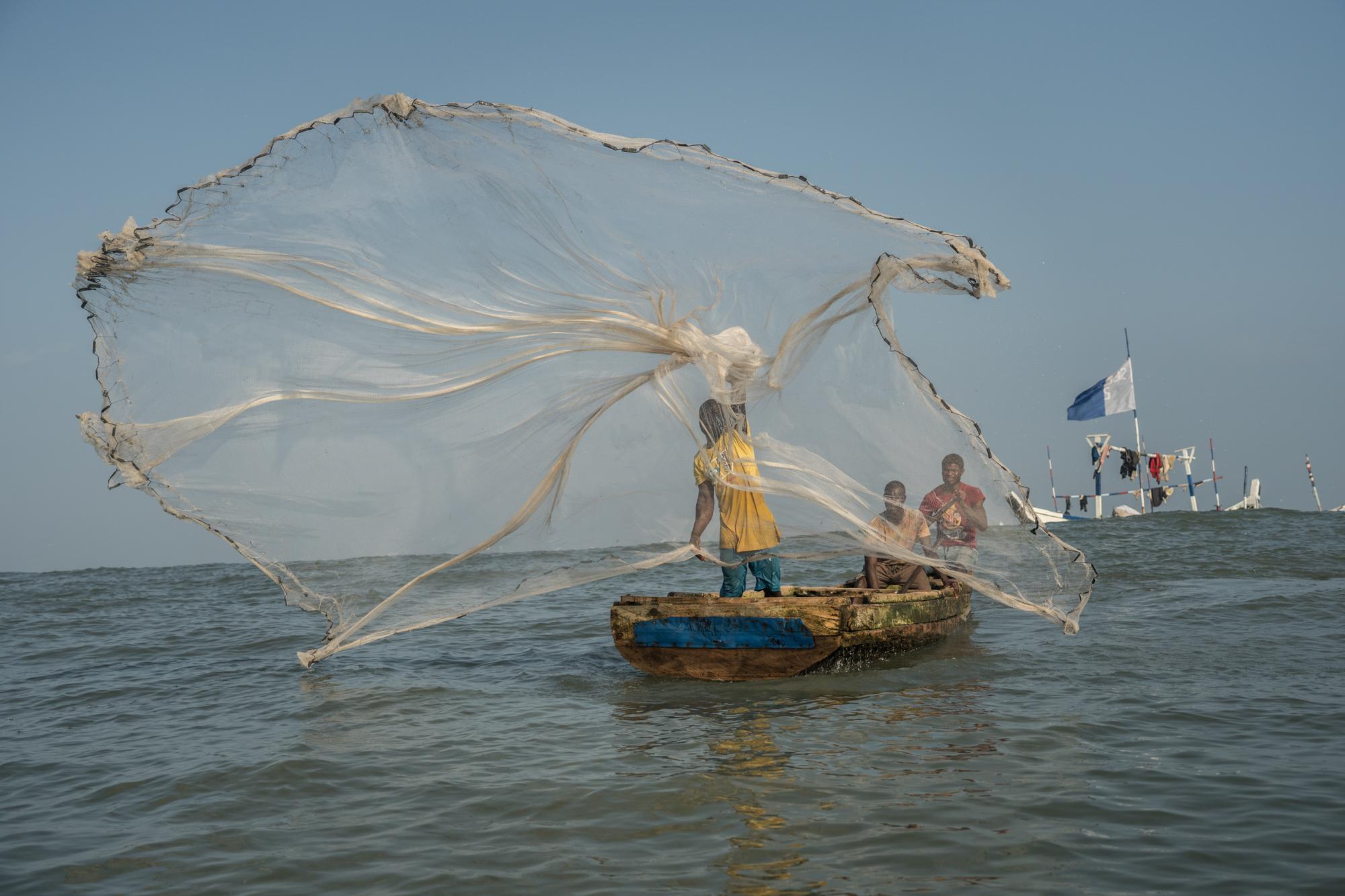 Fisherman throws the net to catch fish in the Gulf of Guinea, Jamestown, Accra. Due to illegal fishing trawlers, unsustainable fishing practices...