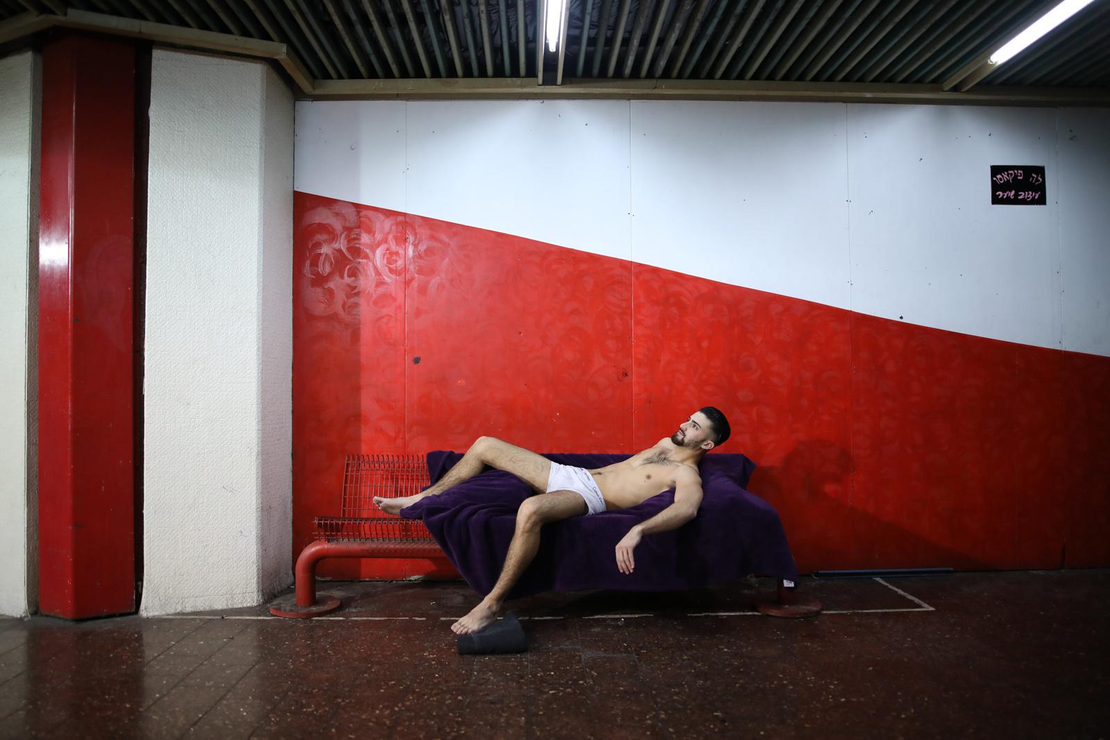 Tel Aviv's Central Bus Station  - A man poses for an artist as a model at the Central Bus...