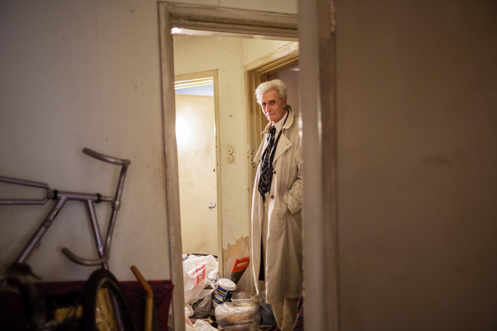 LONDON, UNITED KINGDOM - SEPTEMBER 09, 2013: George stands in his cluttered hallway, about to...