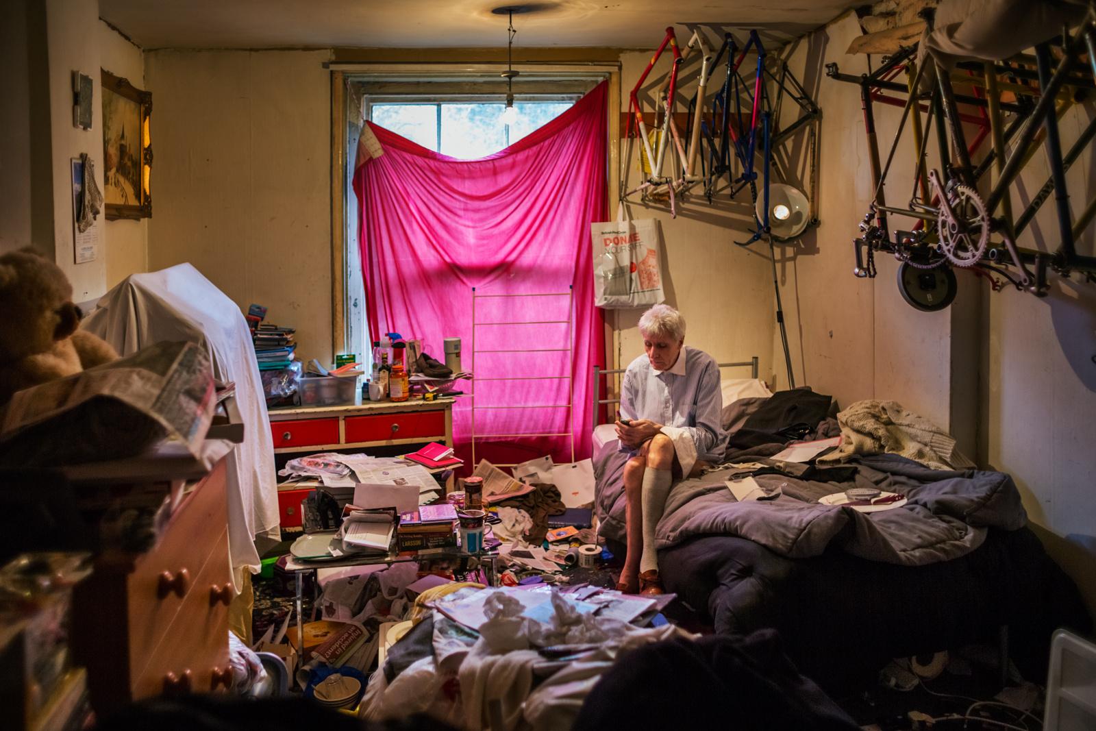 LONDON, UNITED KINGDOM - MARCH 26, 2014: George sits in his cluttered bedroom about one year...