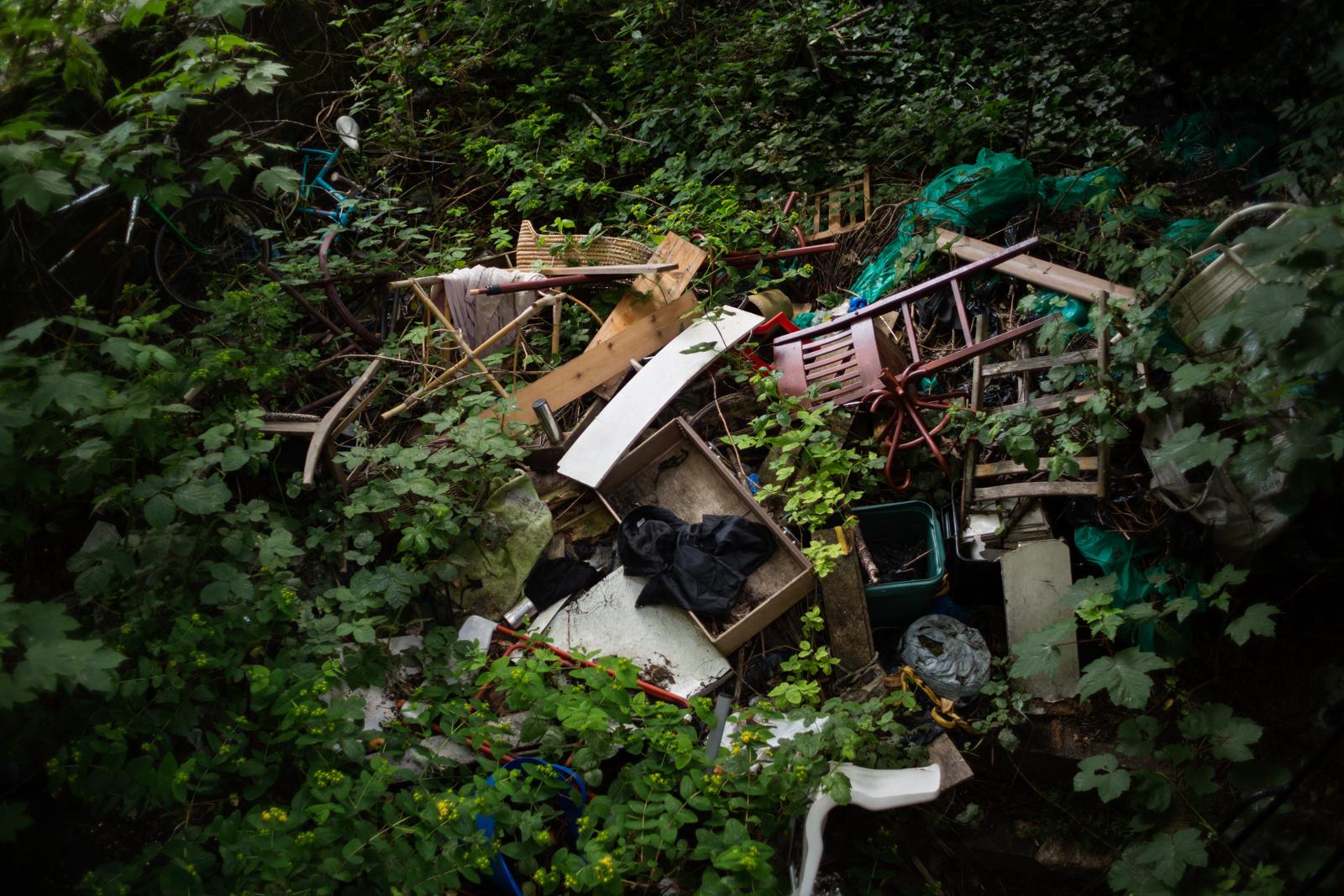 LONDON, UNITED KINGDOM - JUNE 16, 2013: Broken furniture lie in George's overgrown garden...