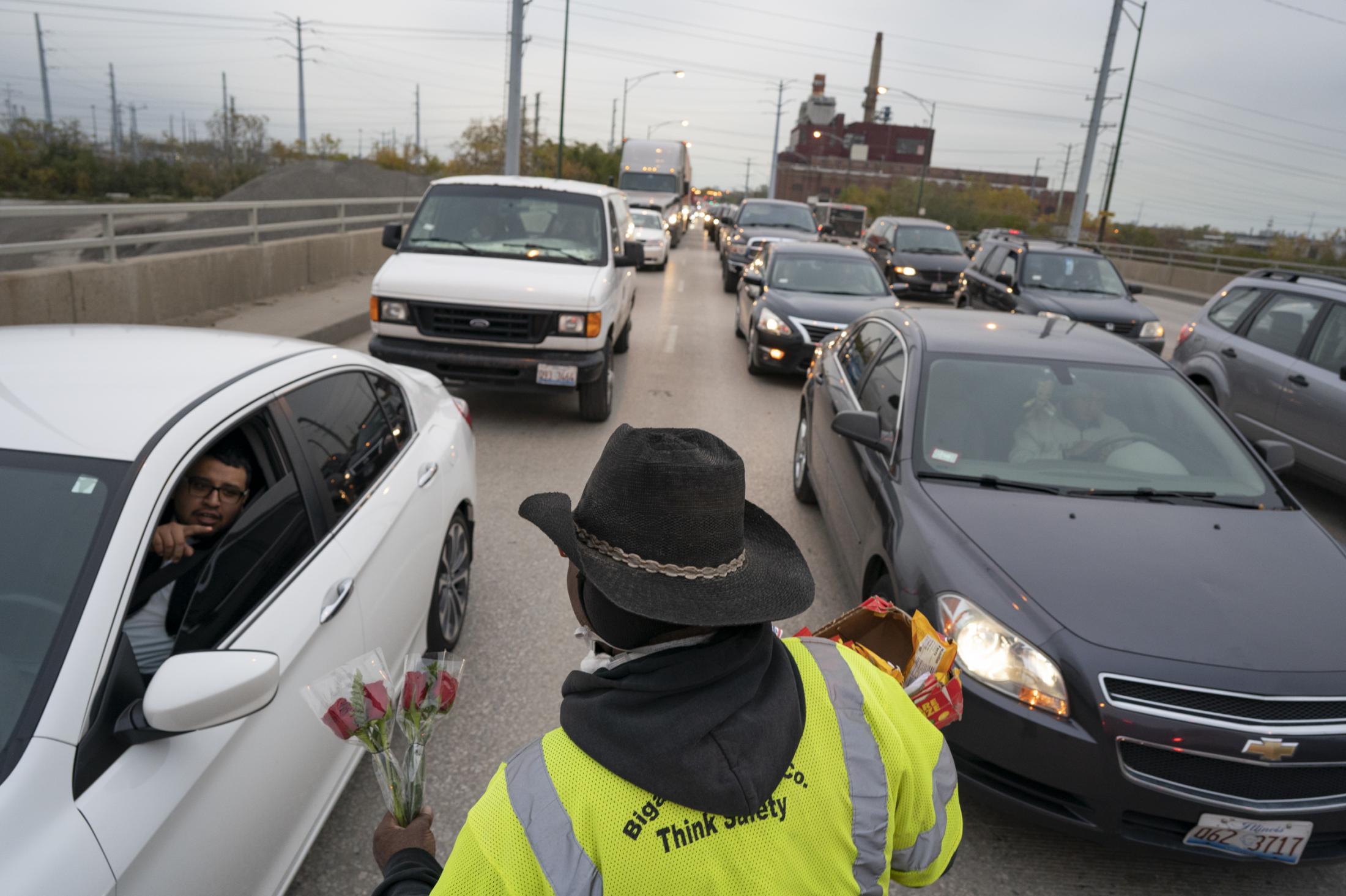 People - John Williams approaches the traffic to sell roses,...