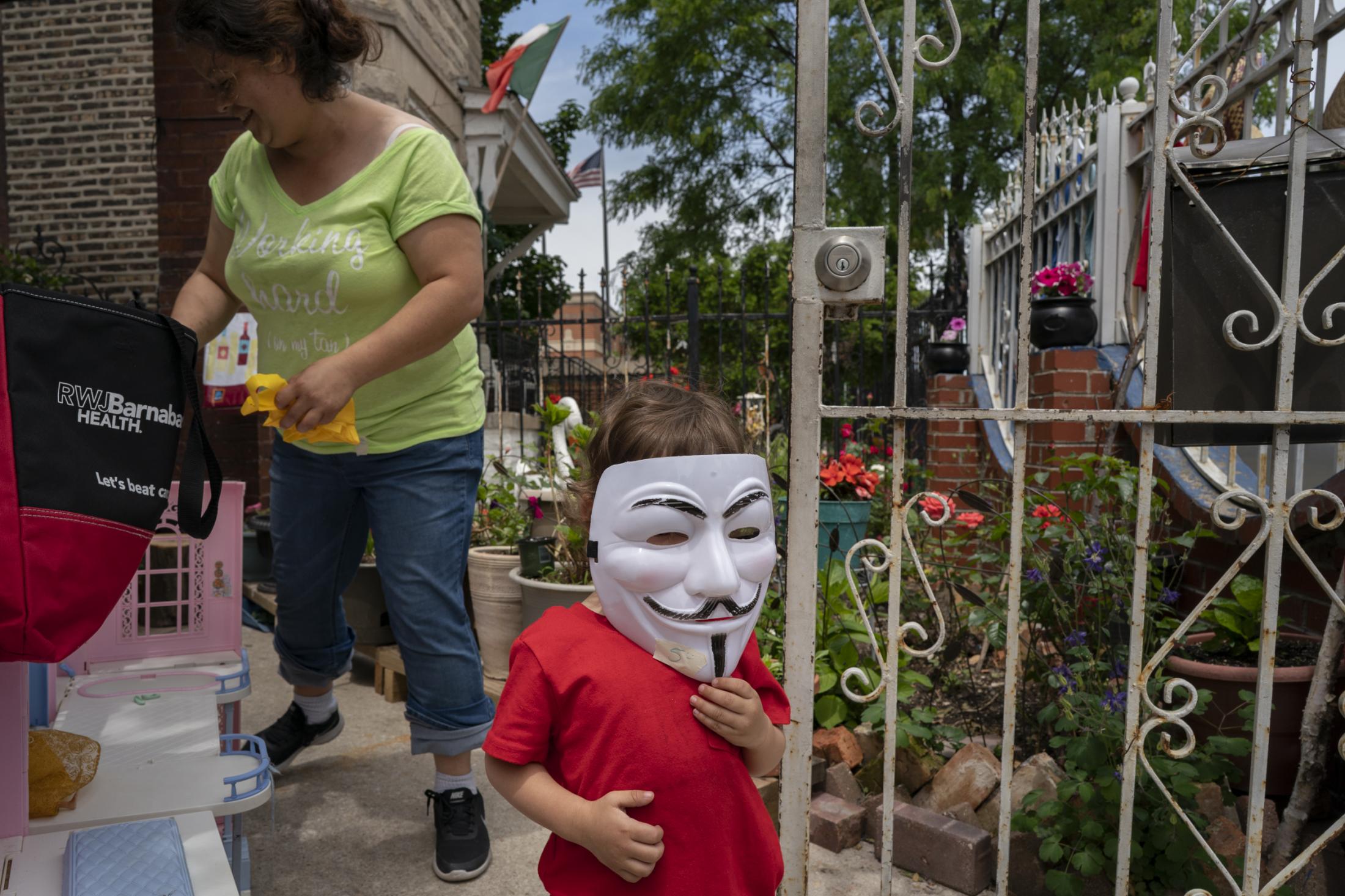 Singles - Valentin Galan, 2, tries on a Guy Fawkes mask while his...